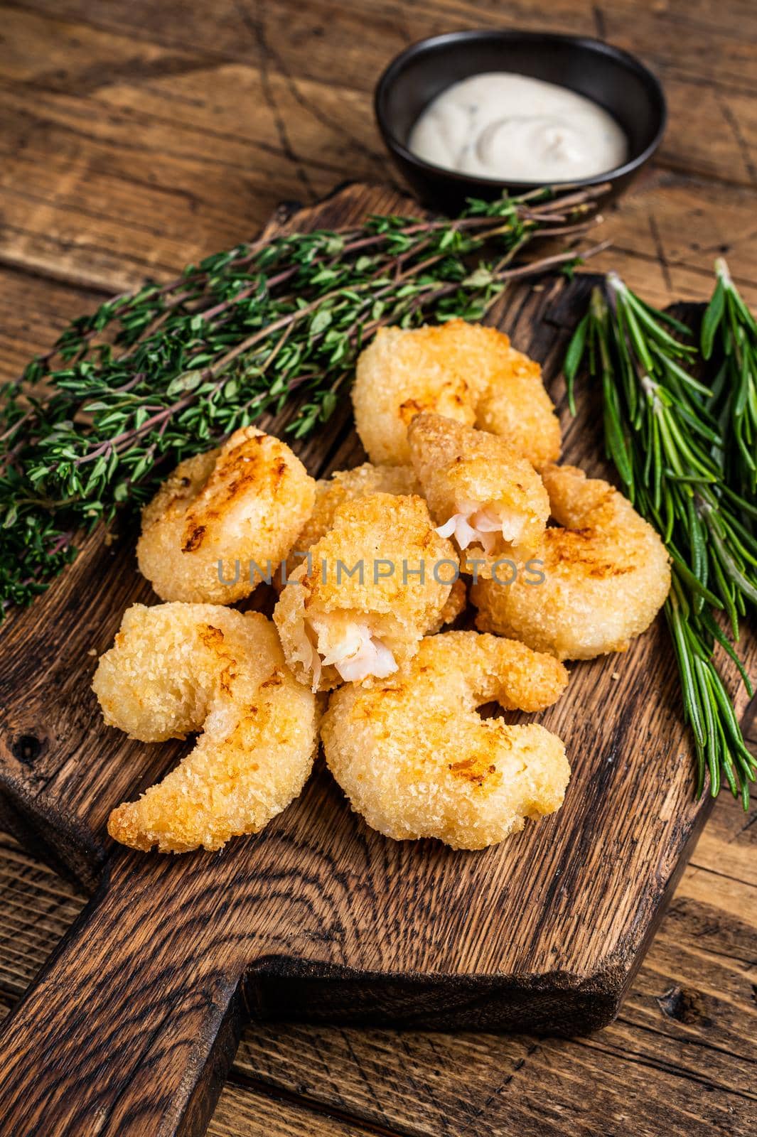 Fried Crispy Shrimps Prawns on a wooden board with sauce. wooden background. Top view.