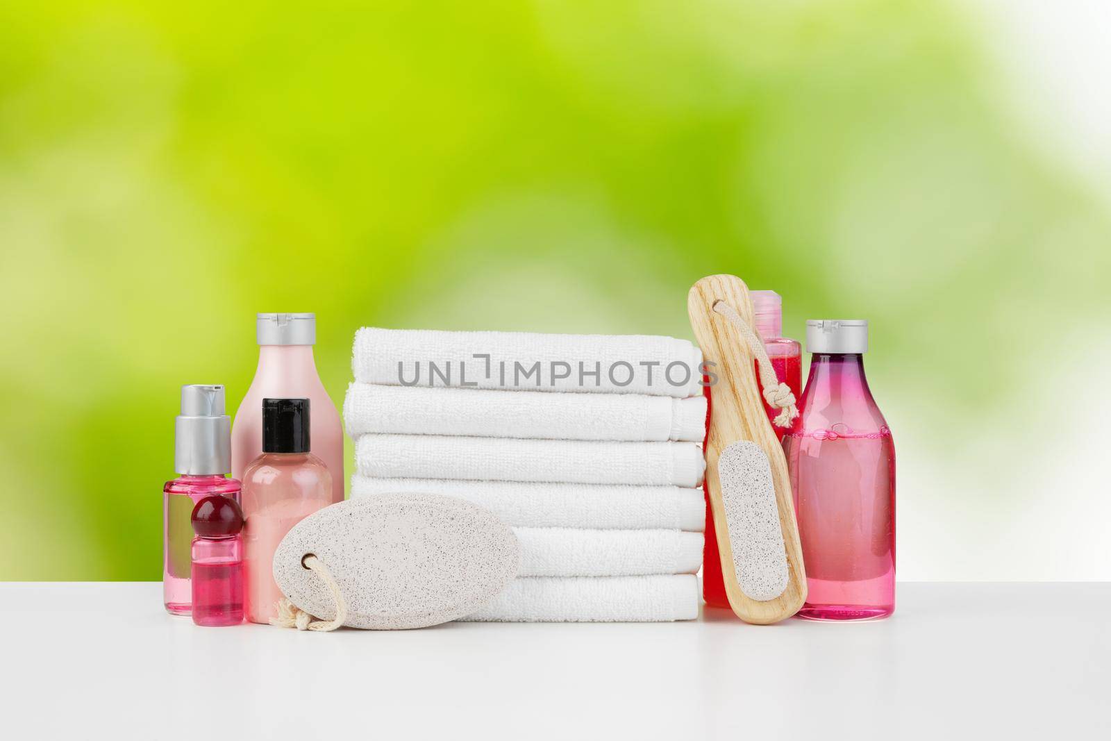 Spa still life with towels and skincare cosmetics against blurred background, close up