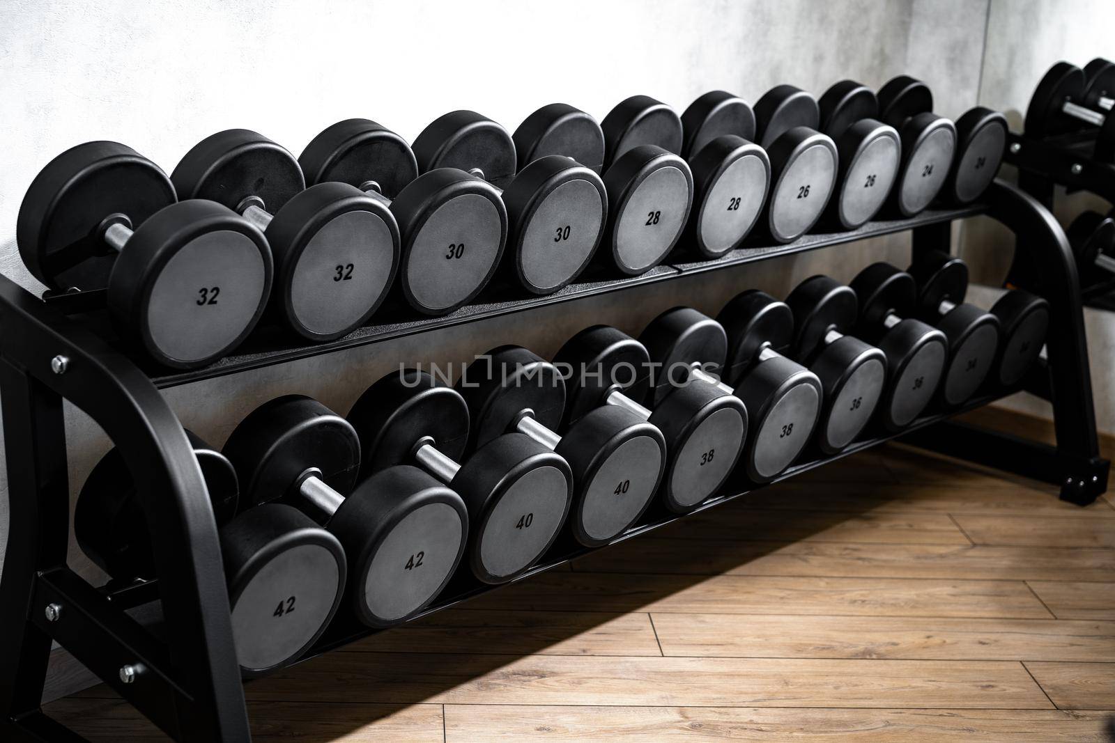 Rows of metal dumbbells on rack for bodybuilding in a gym