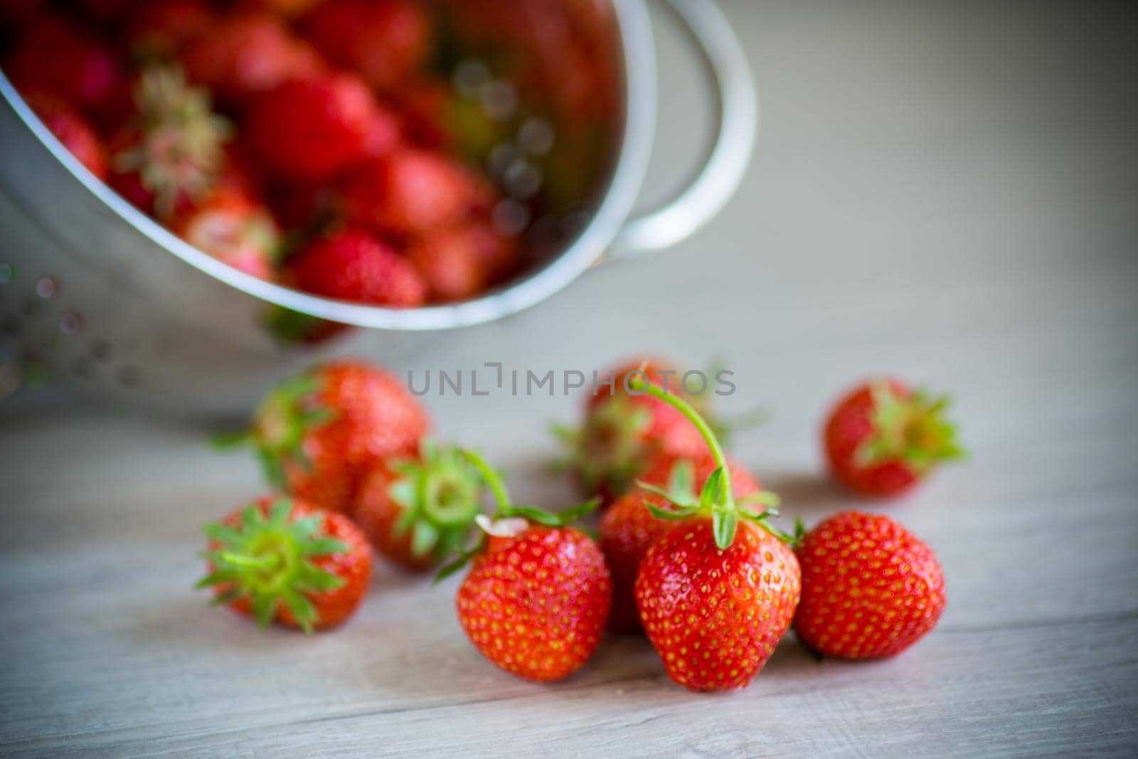 red ripe natural strawberries on a wooden table by Rawlik