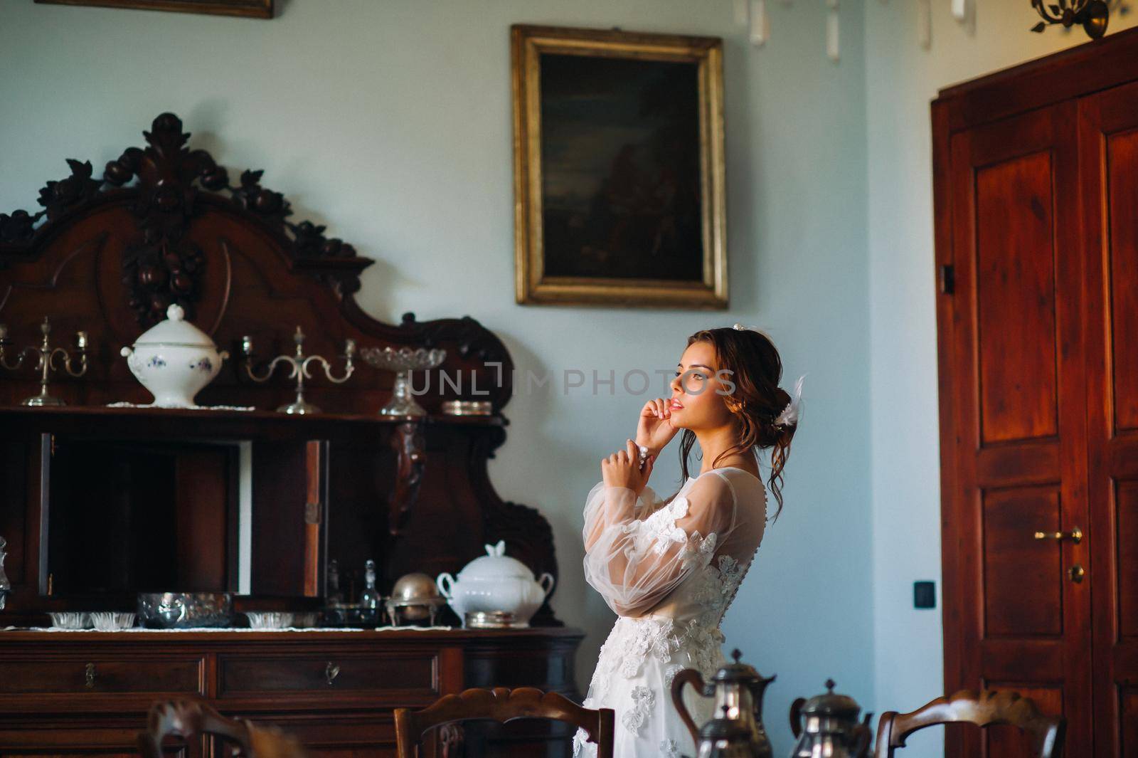 a bride in underwear and a white robe in the interior of a Villa in Italy at a wedding.morning of the bride in Tuscany.boudoir photo session at the Villa