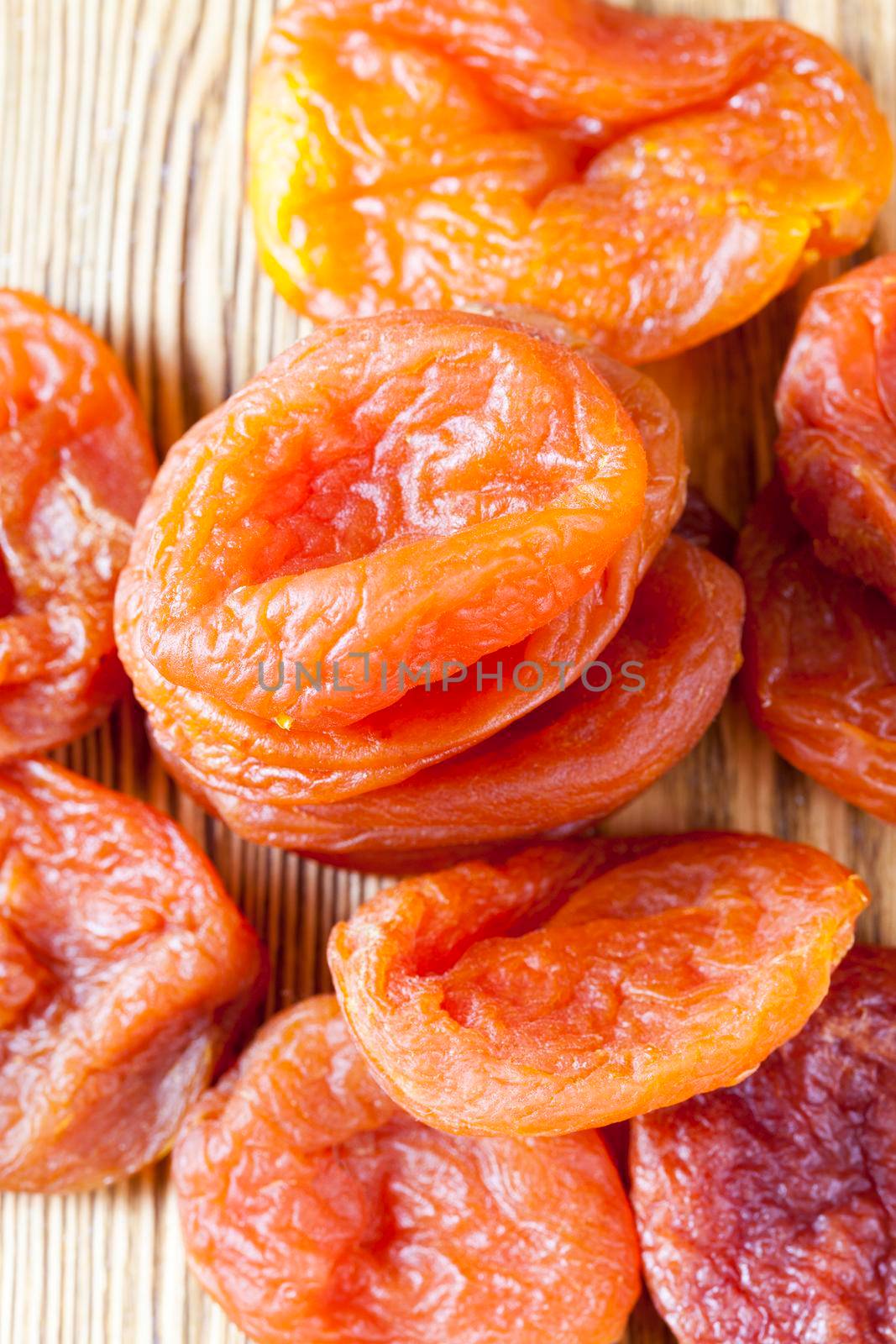orange and yellow dried apricots on a wooden table, close-up