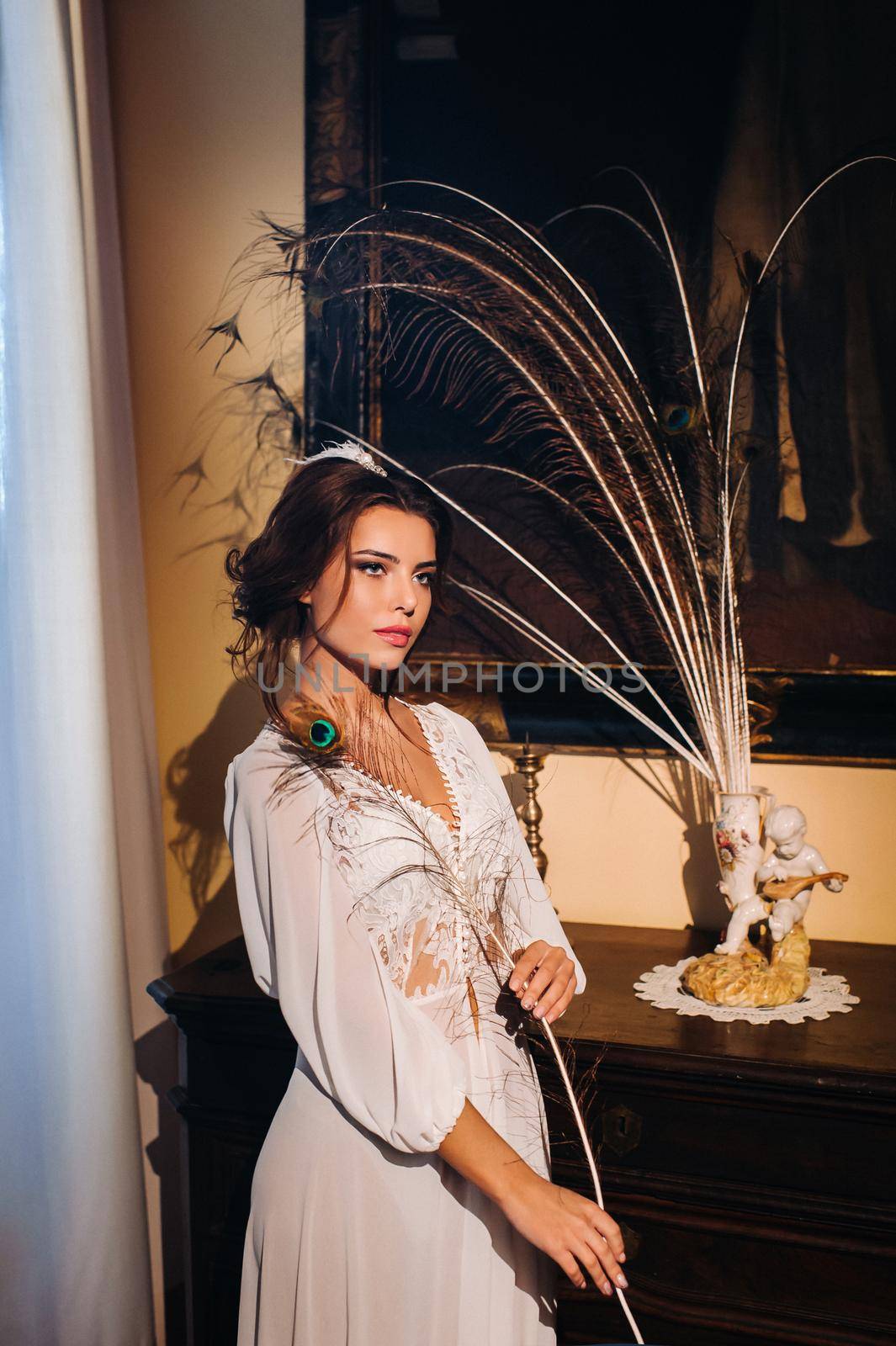 a bride in underwear and a white robe in the interior of a Villa in Italy at a wedding.morning of the bride in Tuscany.boudoir photo session at the Villa