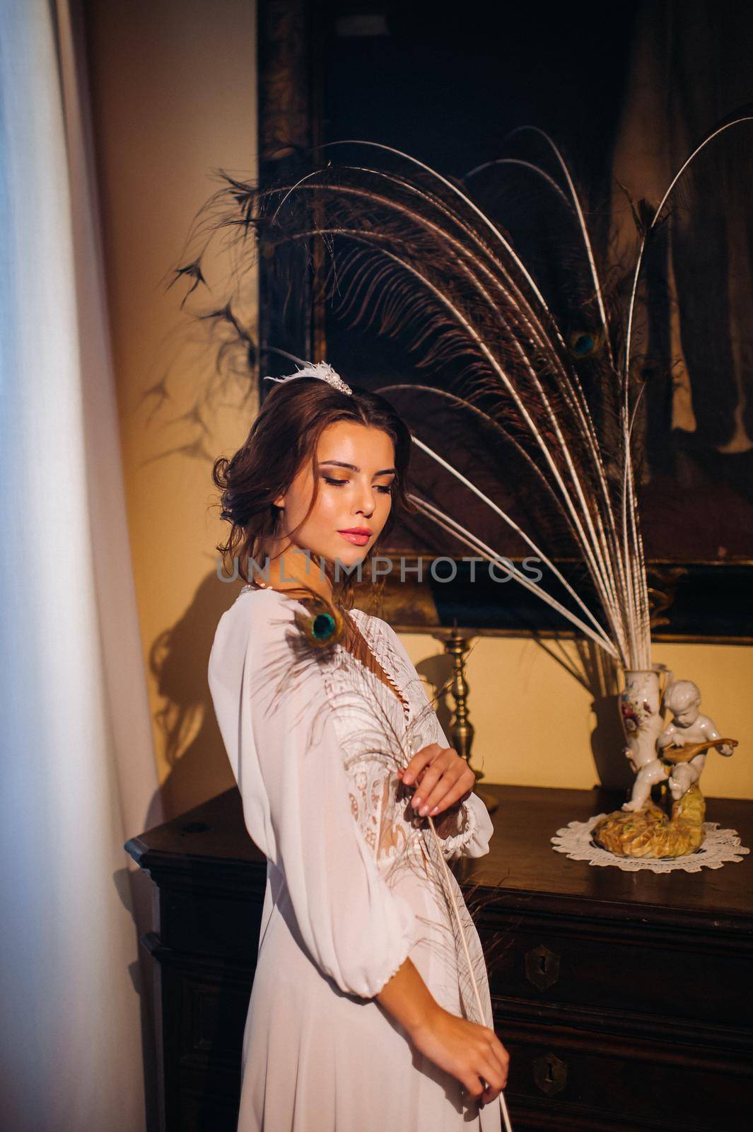 a bride in underwear and a white robe in the interior of a Villa in Italy at a wedding.morning of the bride in Tuscany.boudoir photo session at the Villa