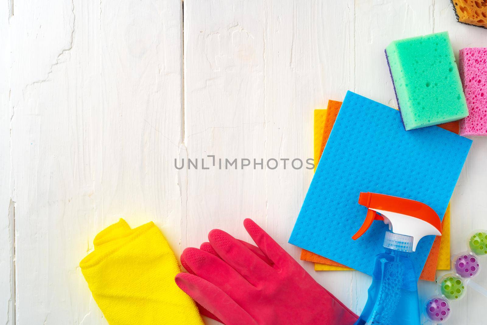 Home cleaning supplies on white wooden background, top view photo