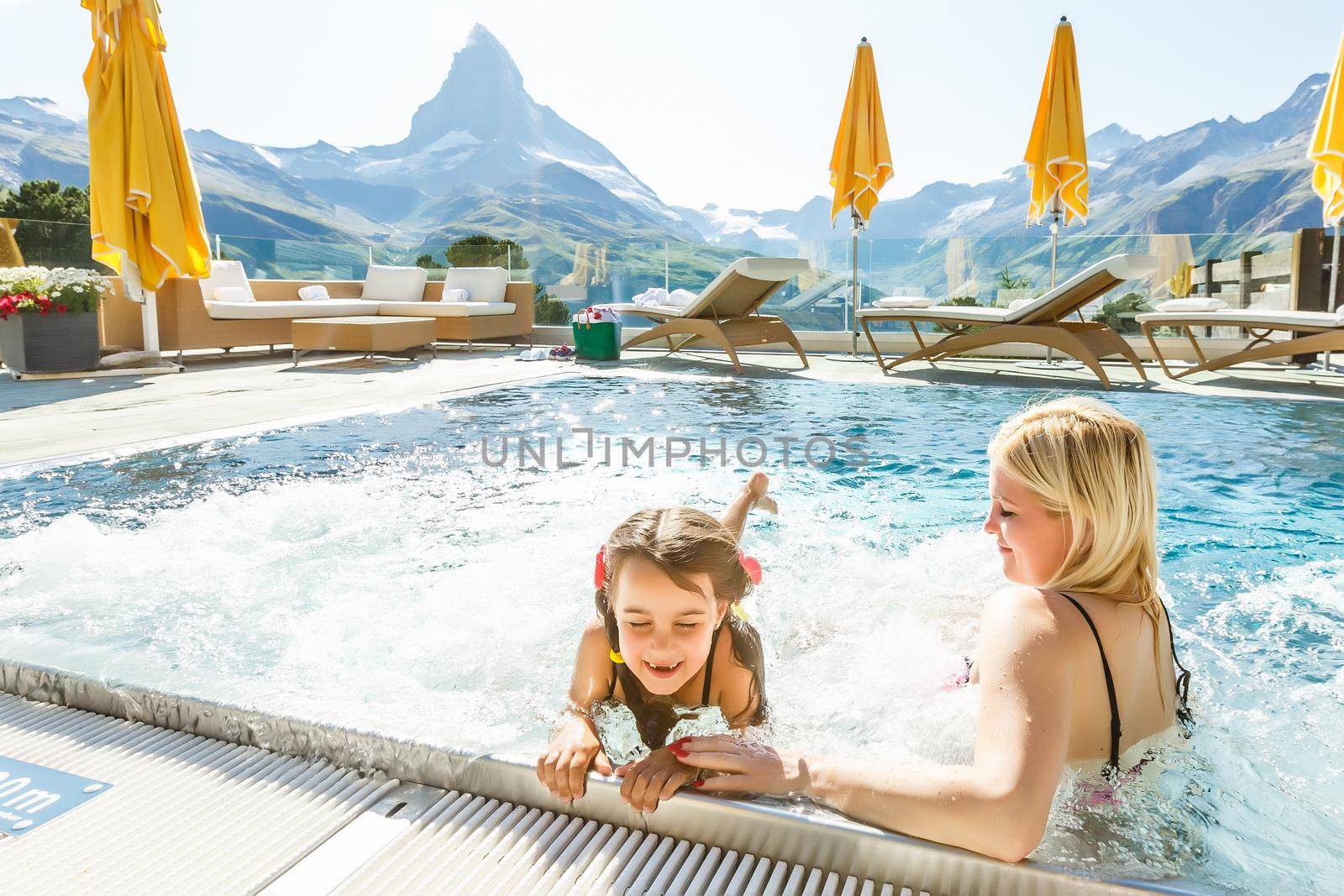 Mother And Child Girl Swimming In Pool In Mountains