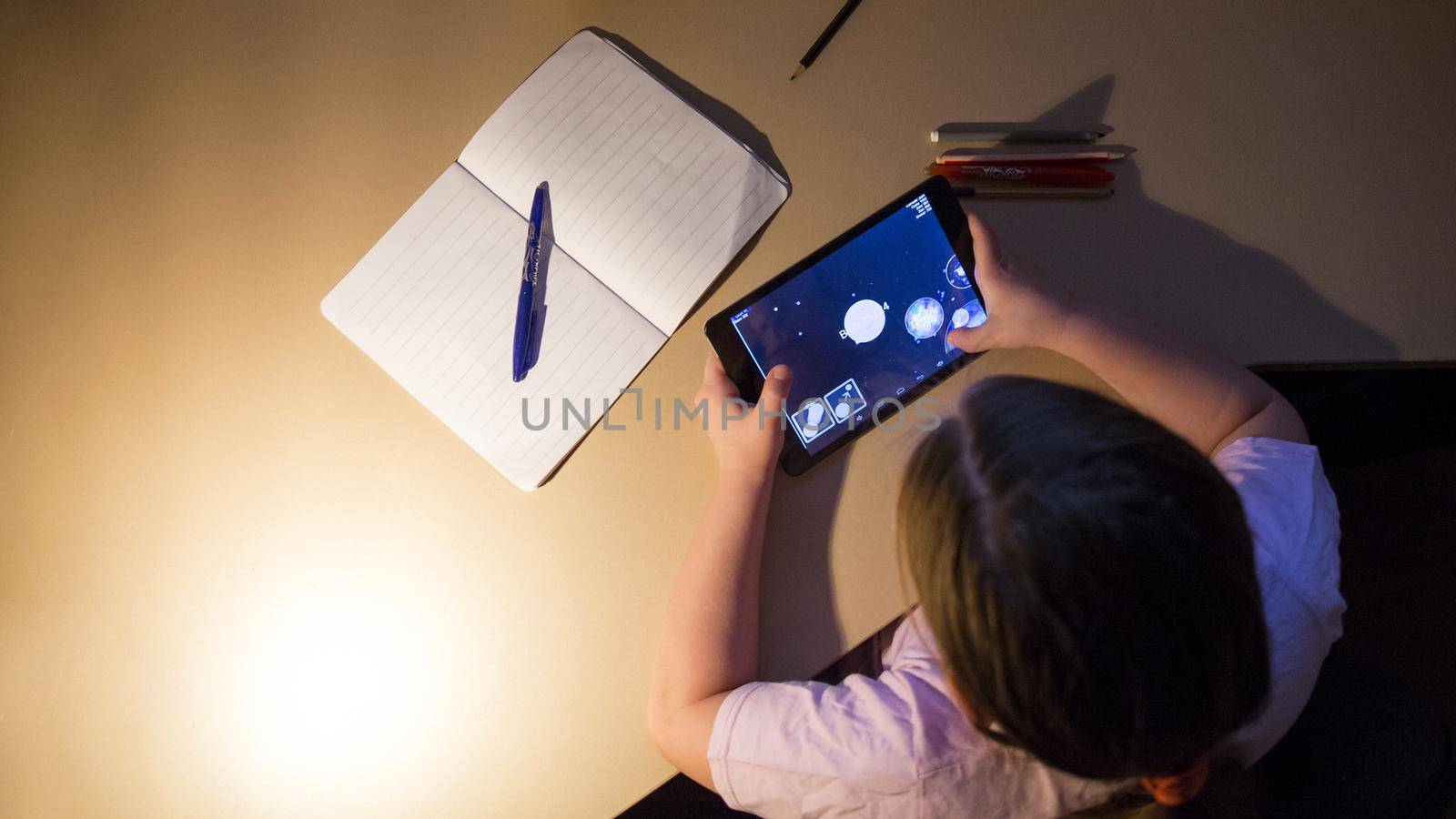 girl playing tablet game evening