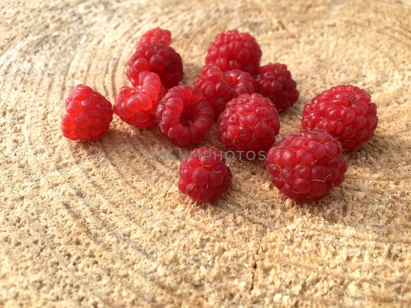 Ripe fresh raspberries on a wooden background, macro close up