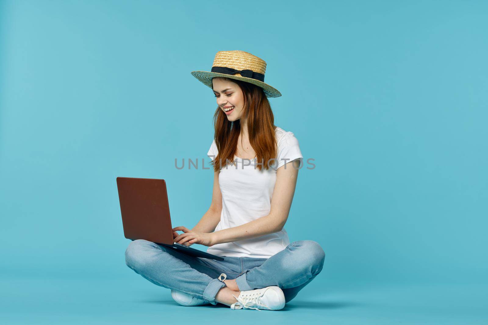 woman with laptop learning internet online education blue background. High quality photo