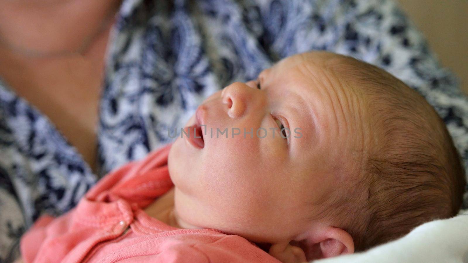Newborn baby sleeping near mother in maternity hospital, close up