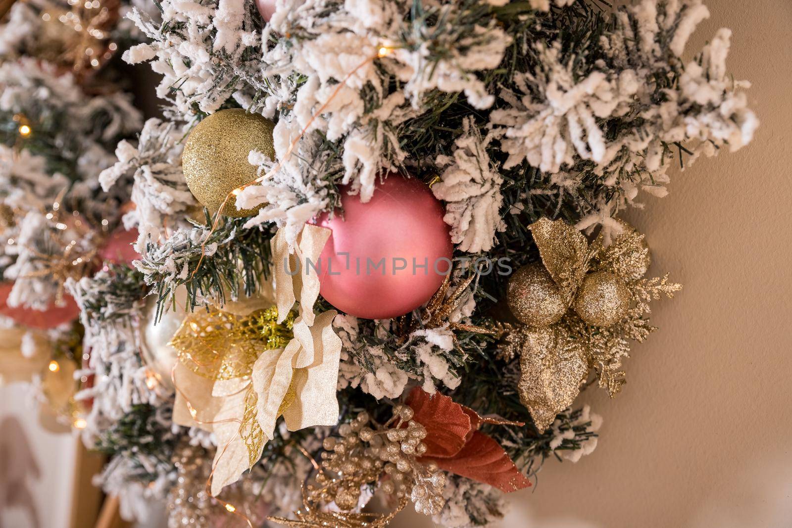 fir branches hanging on a beige wall. Wreath with natural ornaments: bumps, walnuts, cones.