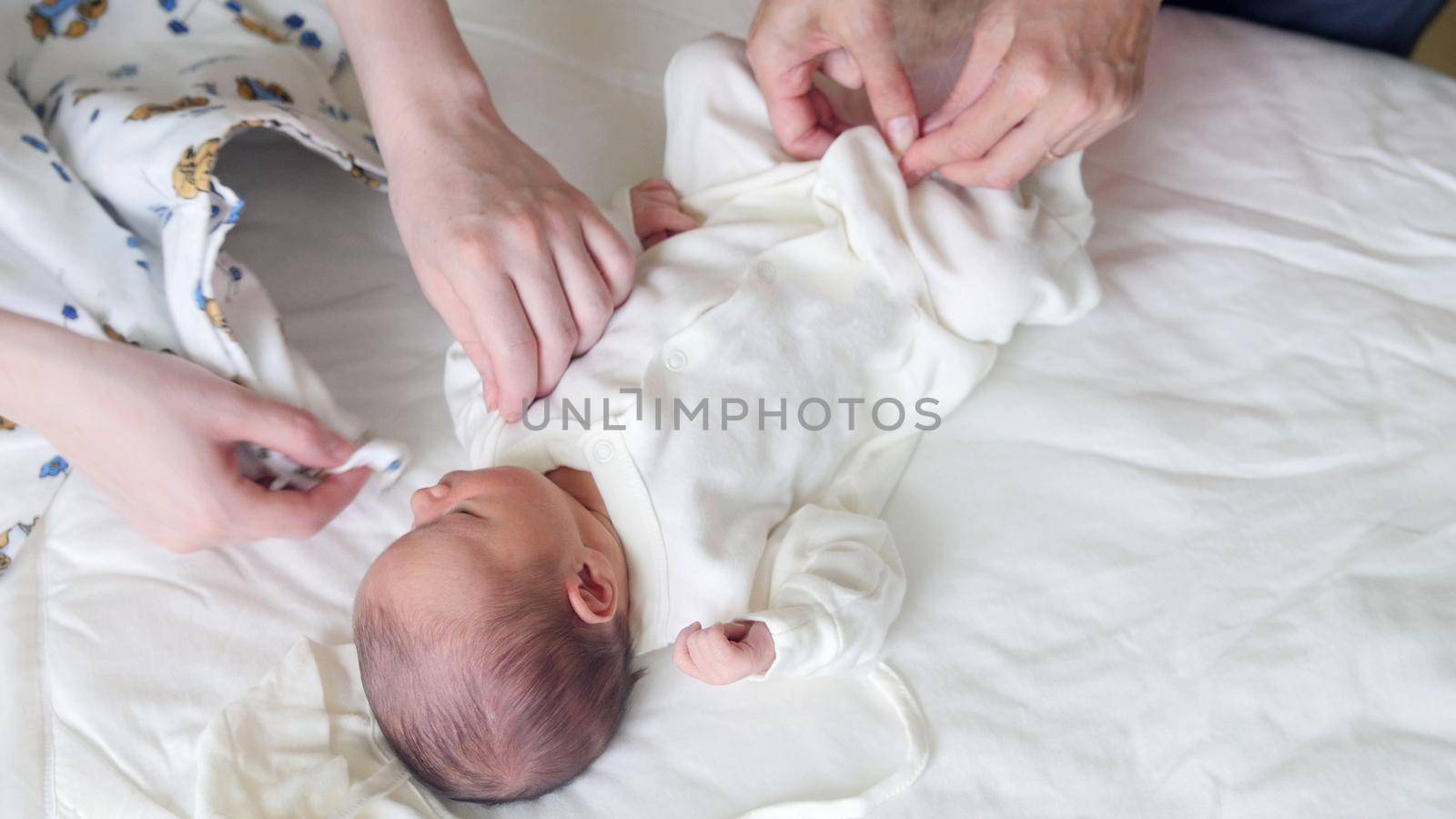 Newborn baby, mother and nurse - swaddling the infant, close up