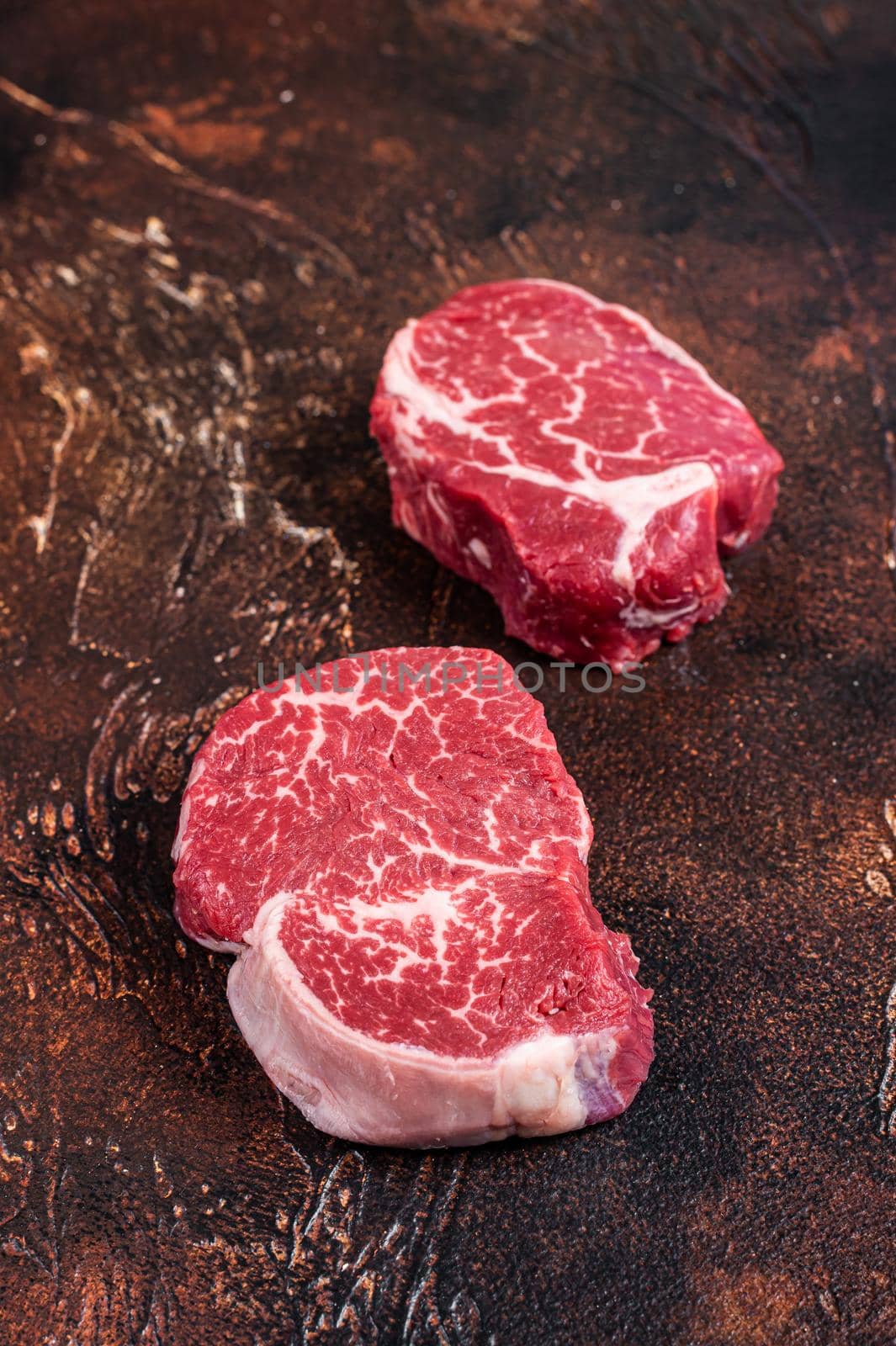 Raw Fillet Mignon tenderloin steaks. Dark background. Top view.