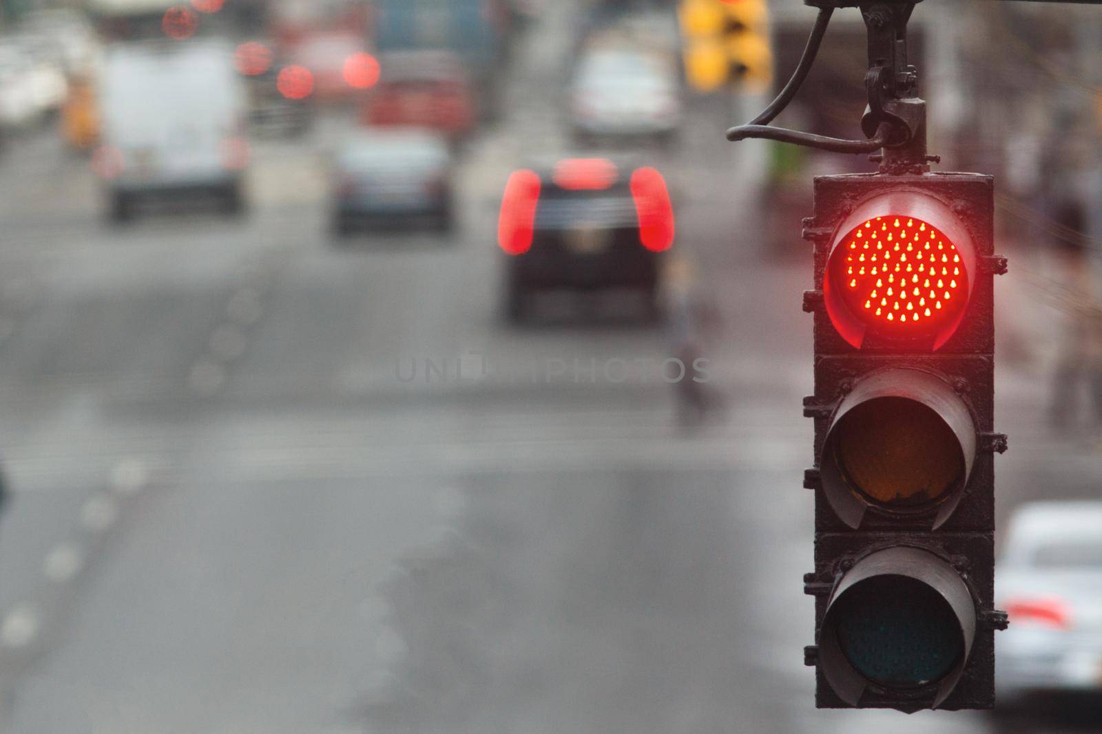 Traffic light in the city with red signal on the background of the road, urban landscape