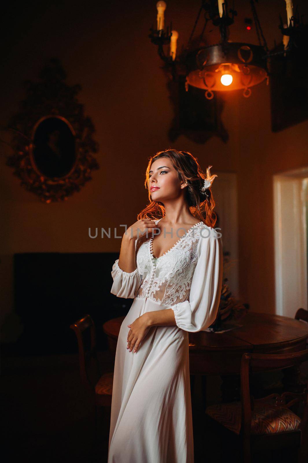 a bride in underwear and a white robe in the interior of a Villa in Italy at a wedding.morning of the bride in Tuscany.boudoir photo session at the Villa