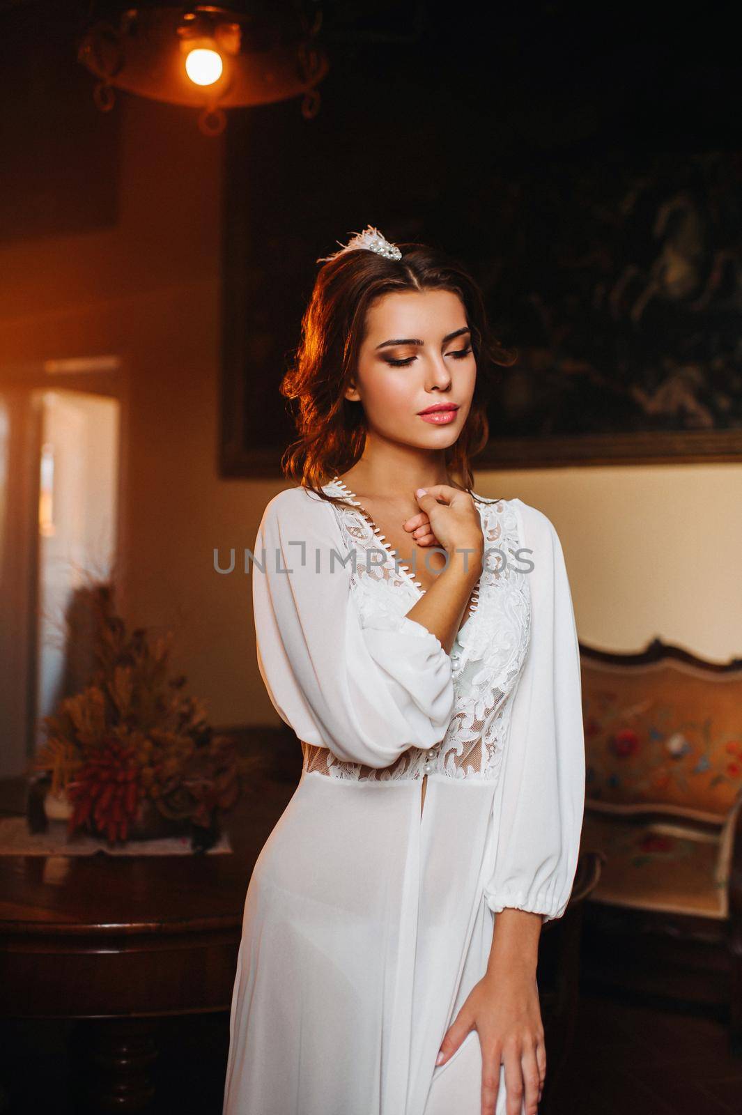 a bride in underwear and a white robe in the interior of a Villa in Italy at a wedding.morning of the bride in Tuscany.boudoir photo session at the Villa