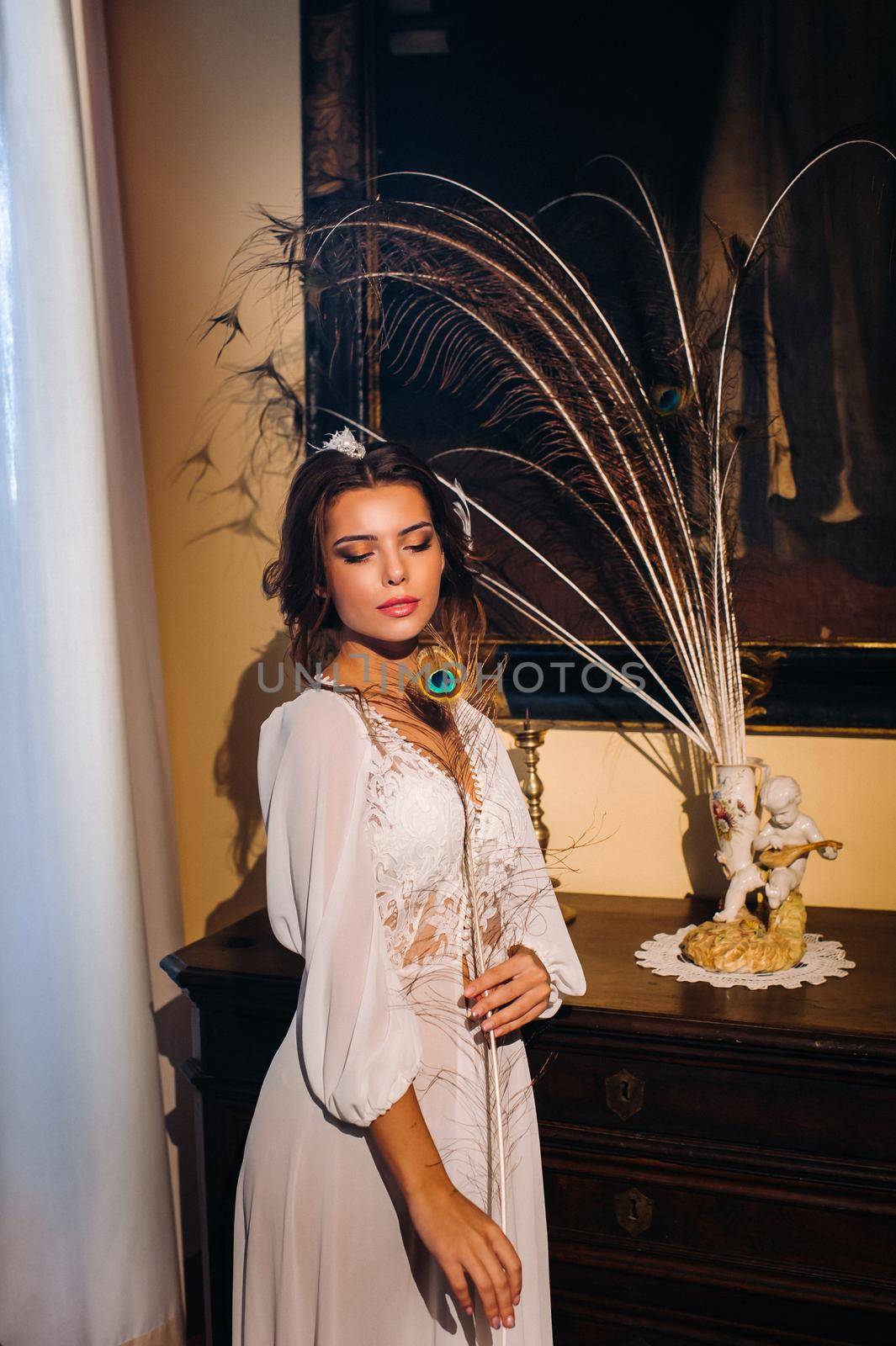 a bride in underwear and a white robe in the interior of a Villa in Italy at a wedding.morning of the bride in Tuscany.boudoir photo session at the Villa