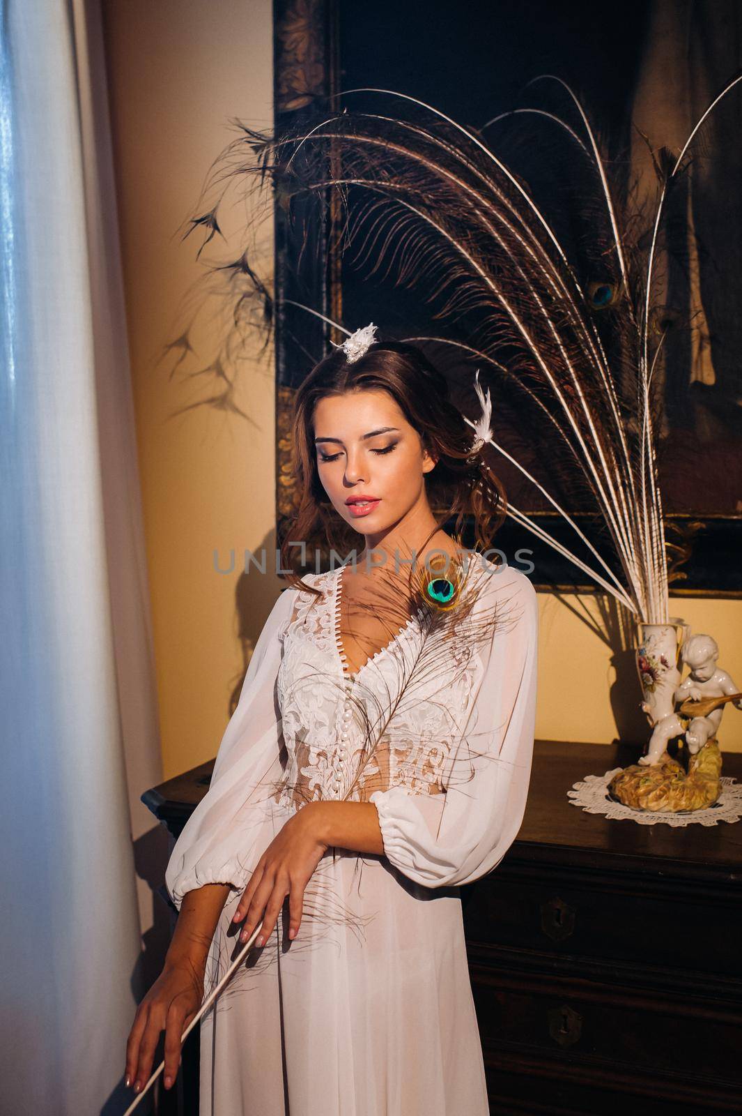 a bride in underwear and a white robe in the interior of a Villa in Italy at a wedding.morning of the bride in Tuscany.boudoir photo session at the Villa