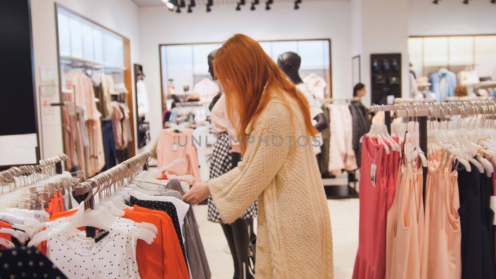 Beauty woman in a clothing store chose a dress - shopping concept, close up