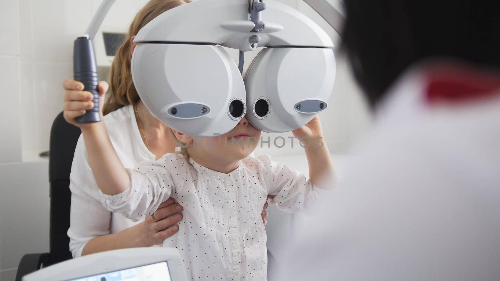 Children ophthalmology - optometrist Checks Eye of little girl, close up