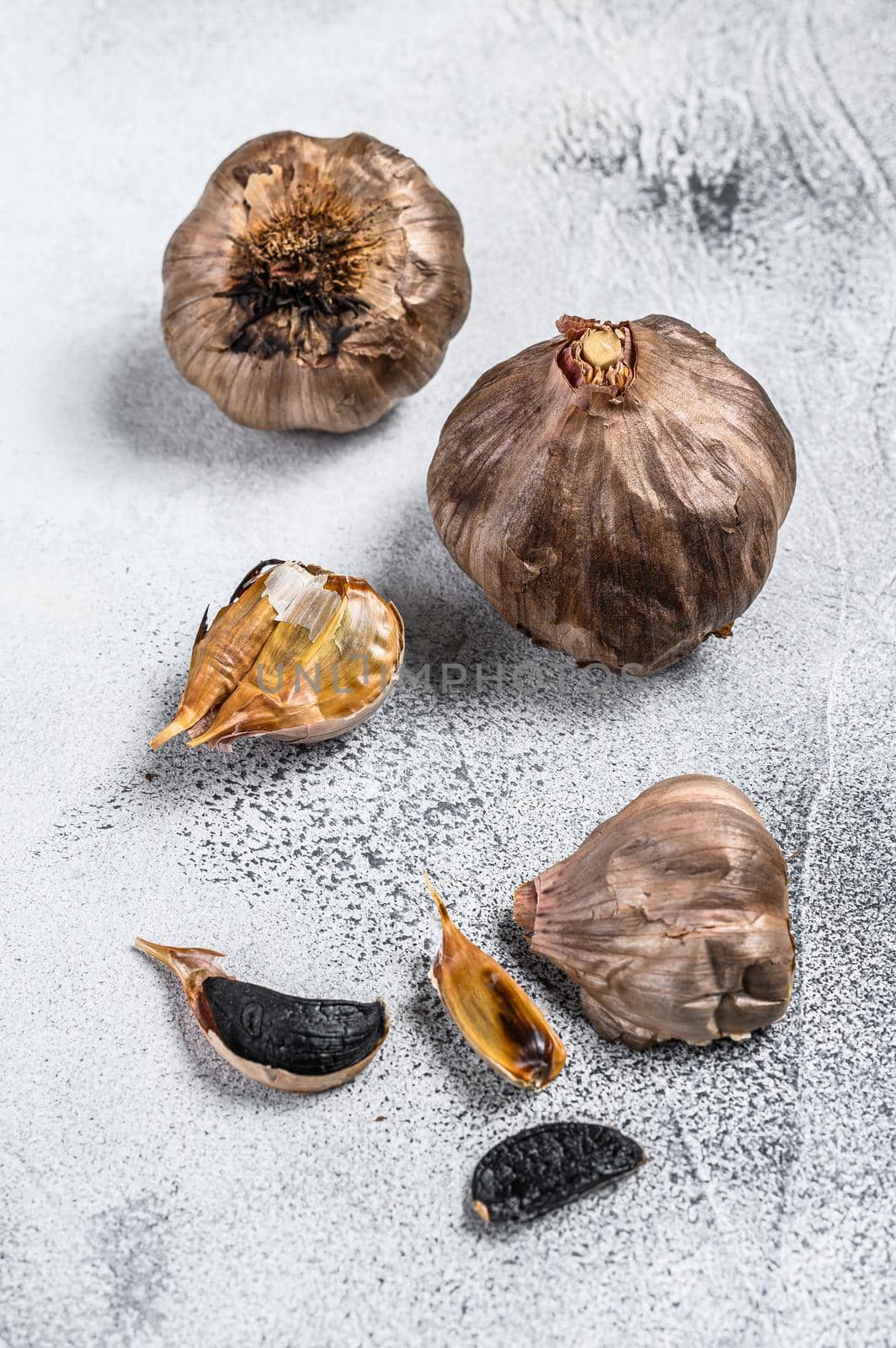 Whole balsamic fermented black garlic. White background. Top view.