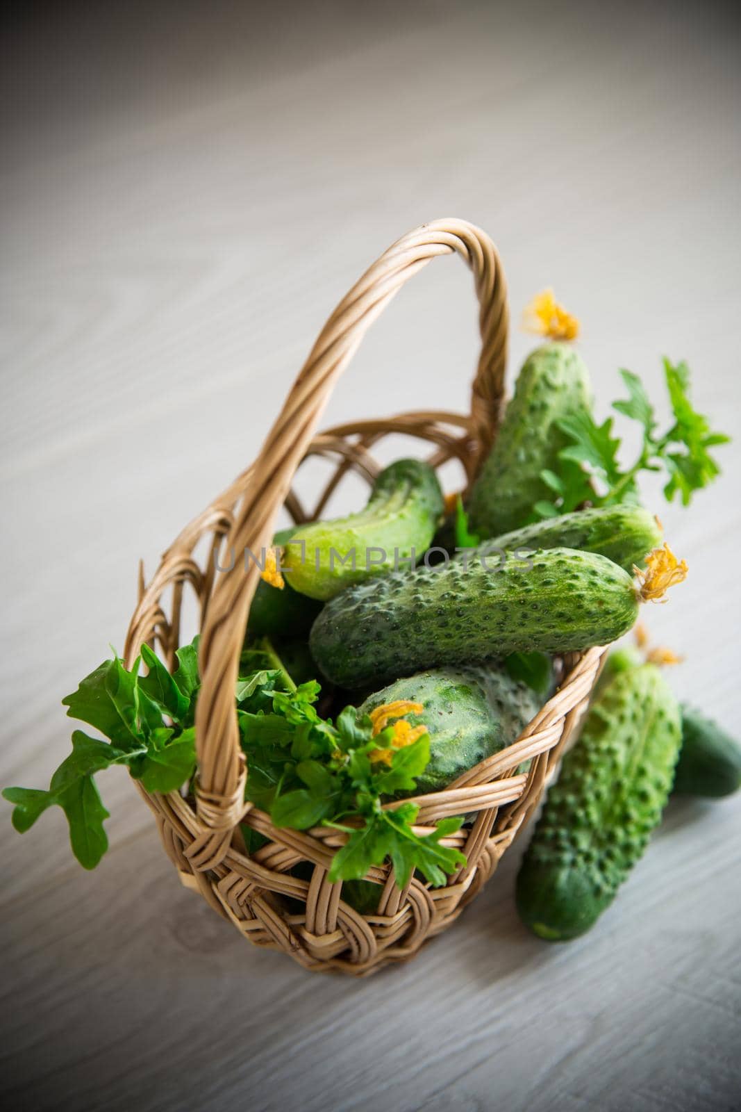 organic cucumbers with herbs on a wooden table by Rawlik