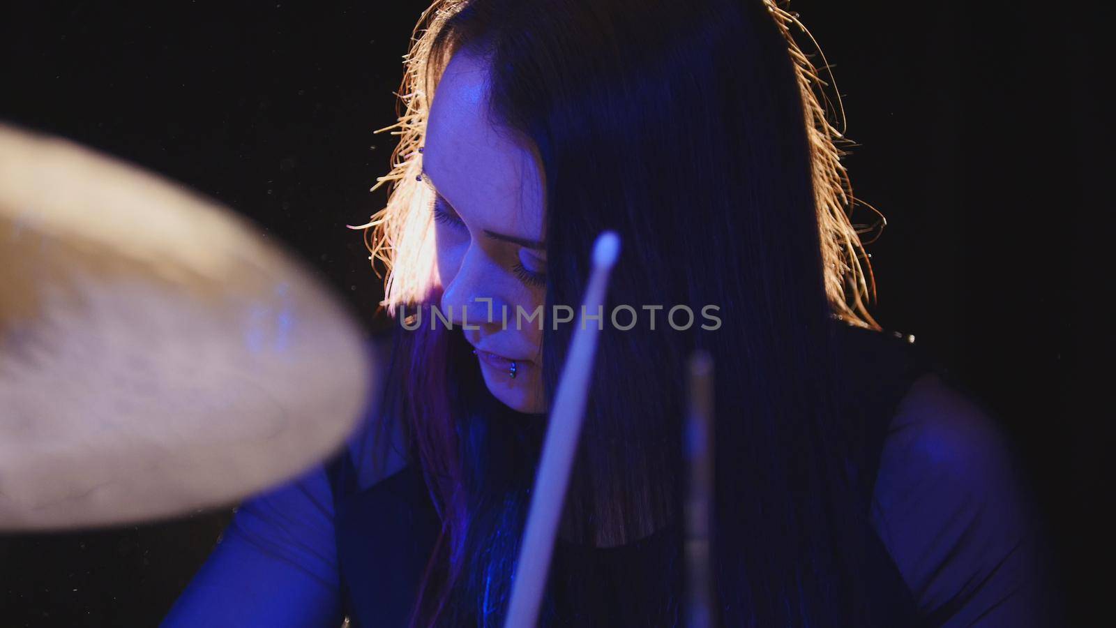 Young woman percussion drummer performing with drums, close up