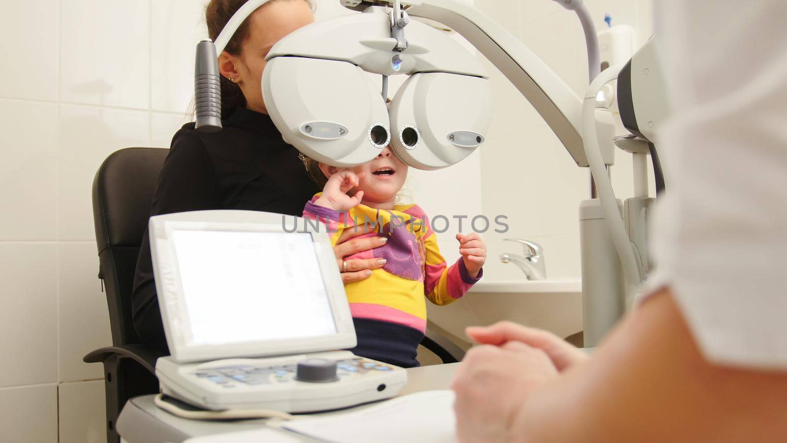 High tehnology in medicine - optometrist in clinic checking little girl's vision - children's ophthalmology by Studia72