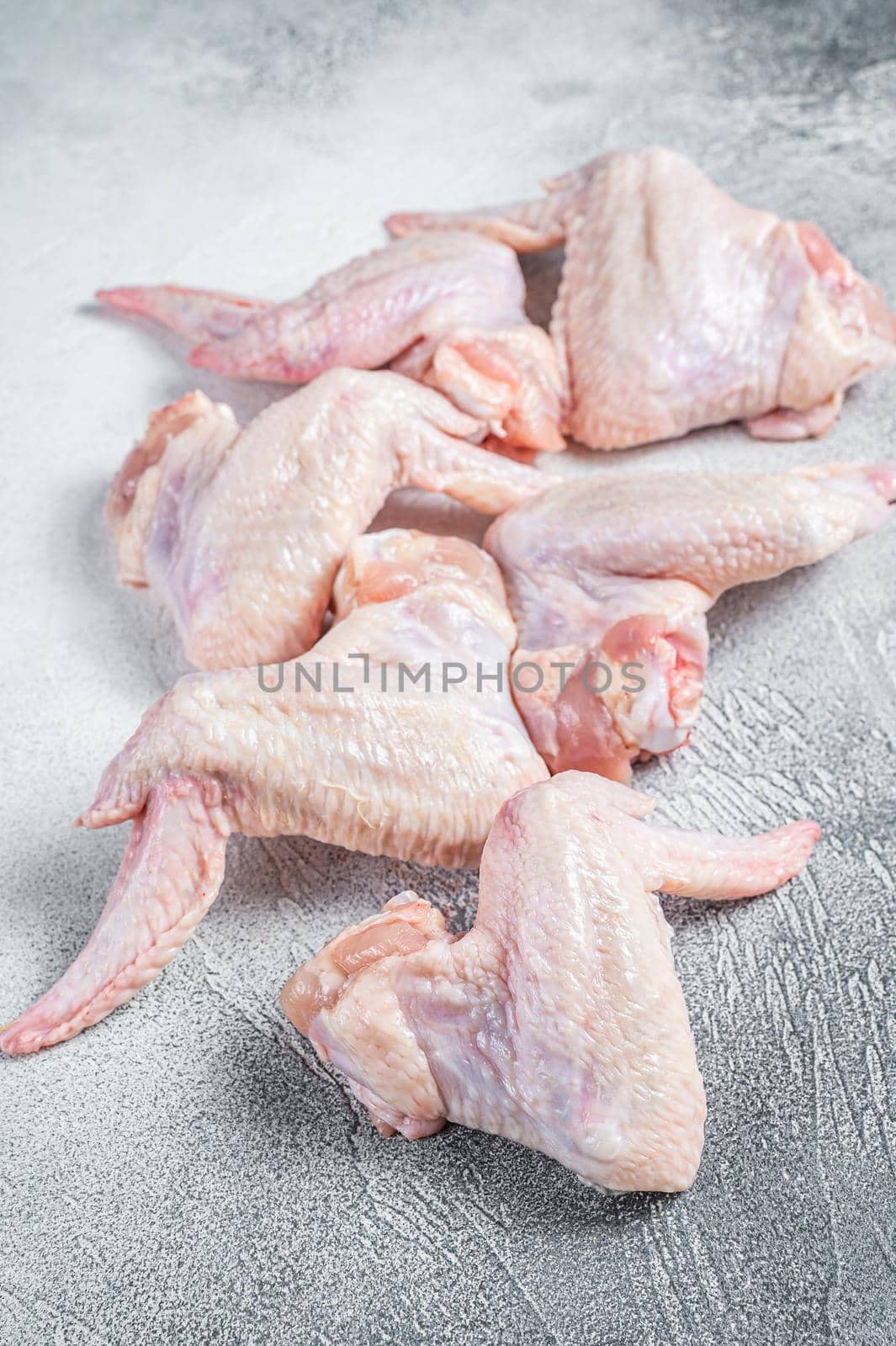 Raw chicken wings on a kitchen table. White background. Top view.