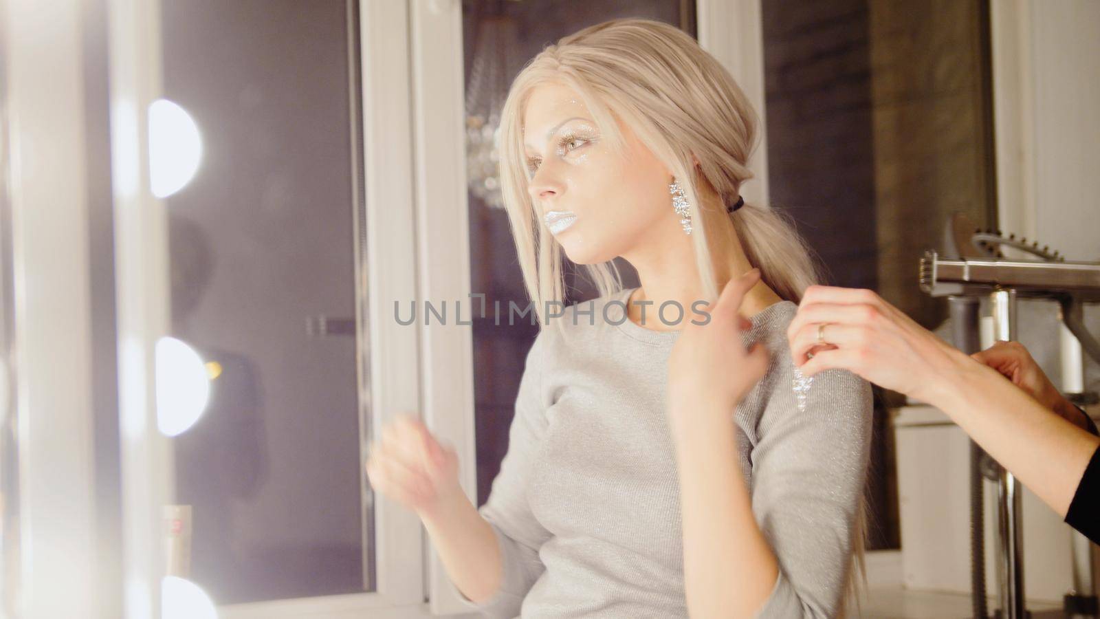 Beauty shop: adorable blonde young woman model wear earrings, close up