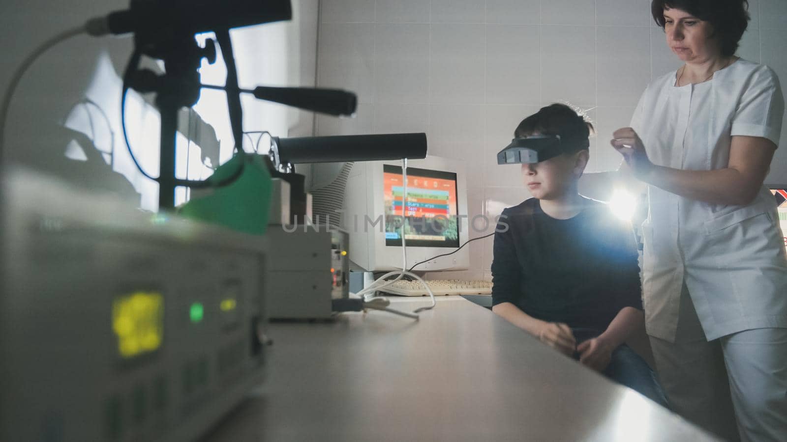 the doctor checks the child's vision with the help of stereovideo virtual reality glasses, wide angle