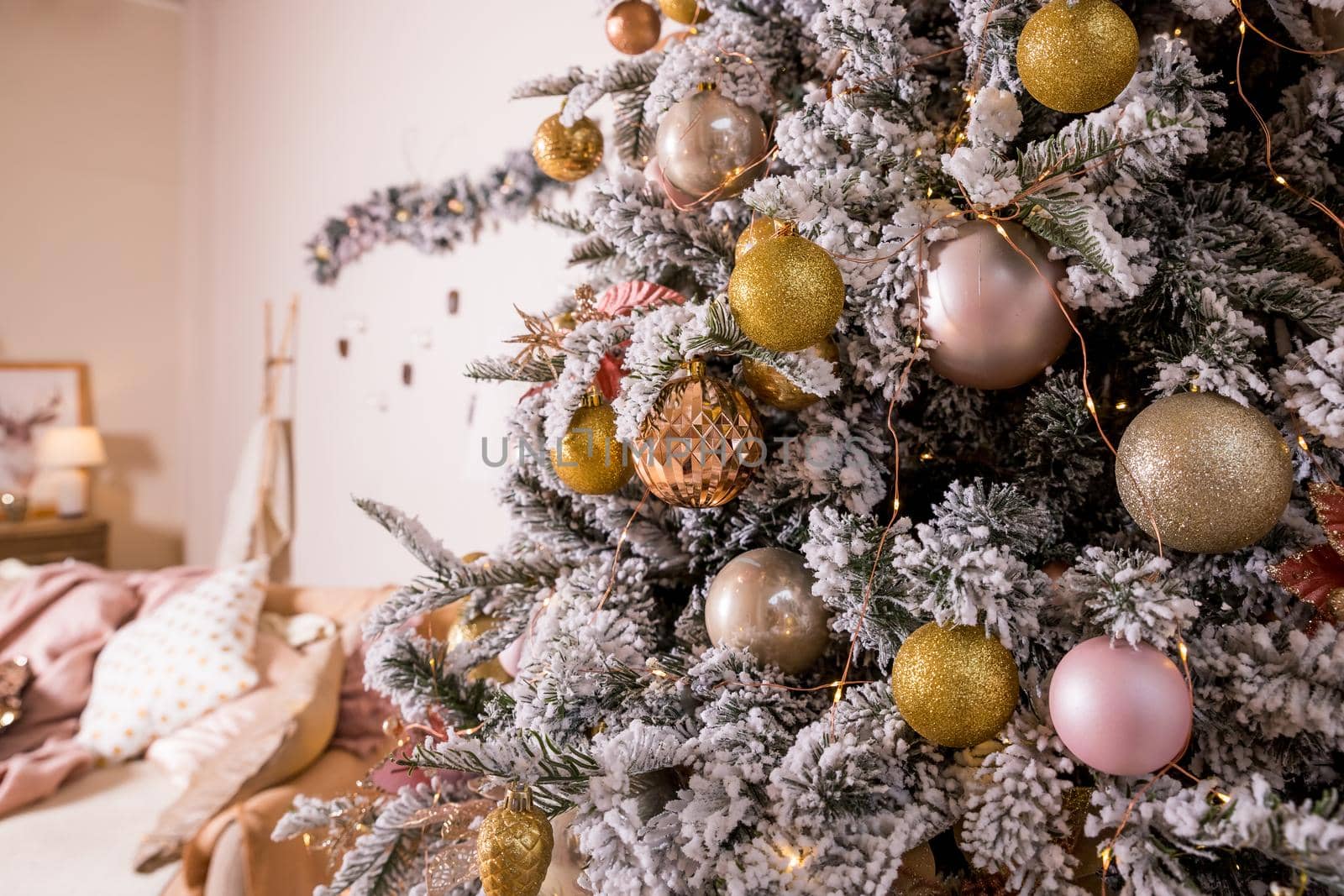 Christmas toys on a fir-tree close up with interior background