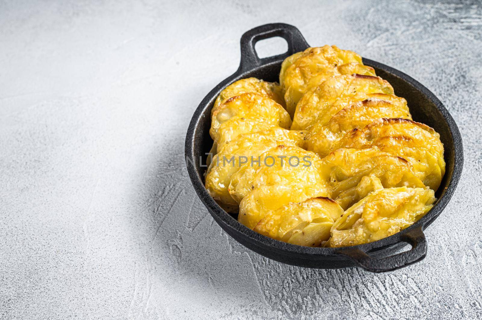 Baked Potato Gratin Dauphinois in a pan. White background. Top View. Copy space by Composter