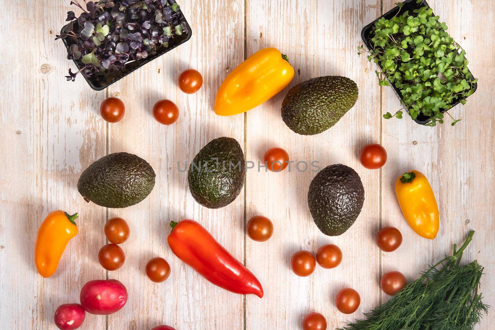 Assorted vegetables lying on a wooden table by Lobachad