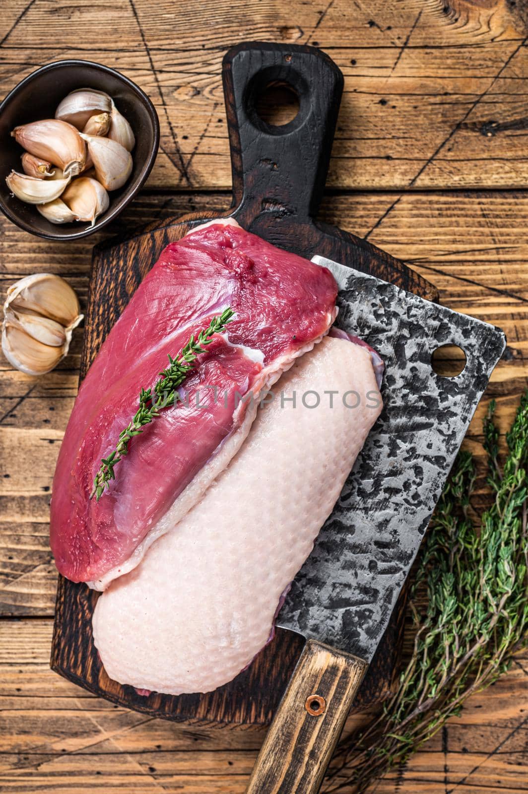 Fresh Raw Duck breast fillet steaks on butcher board with meat cleaver. wooden background. Top View by Composter
