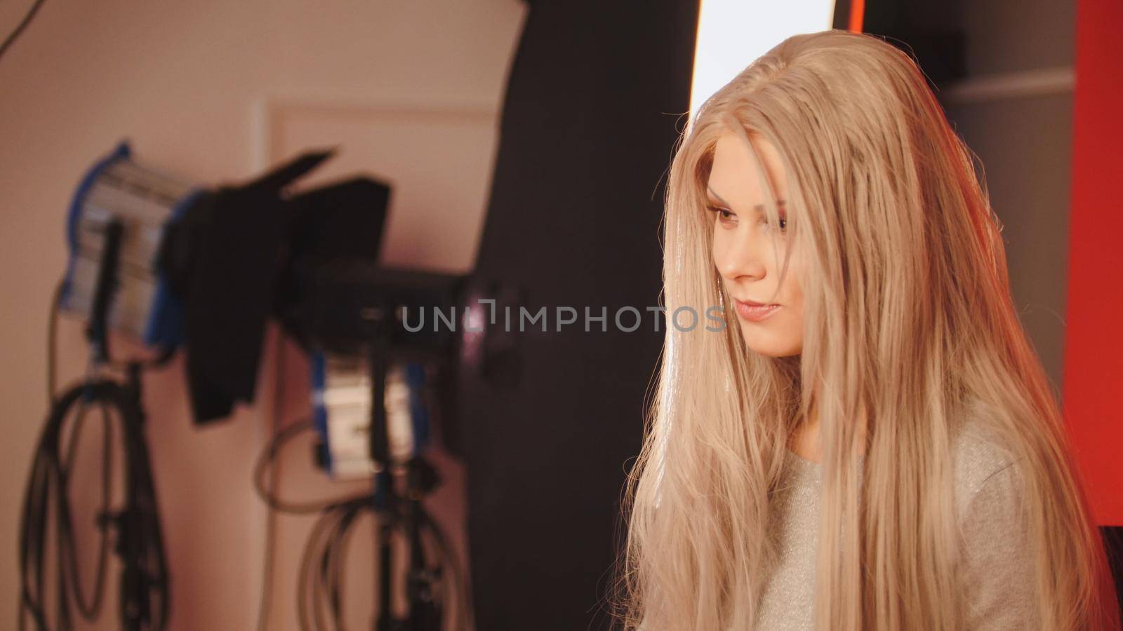 Blonde girl with professional make up posing in studio for photographer , close up