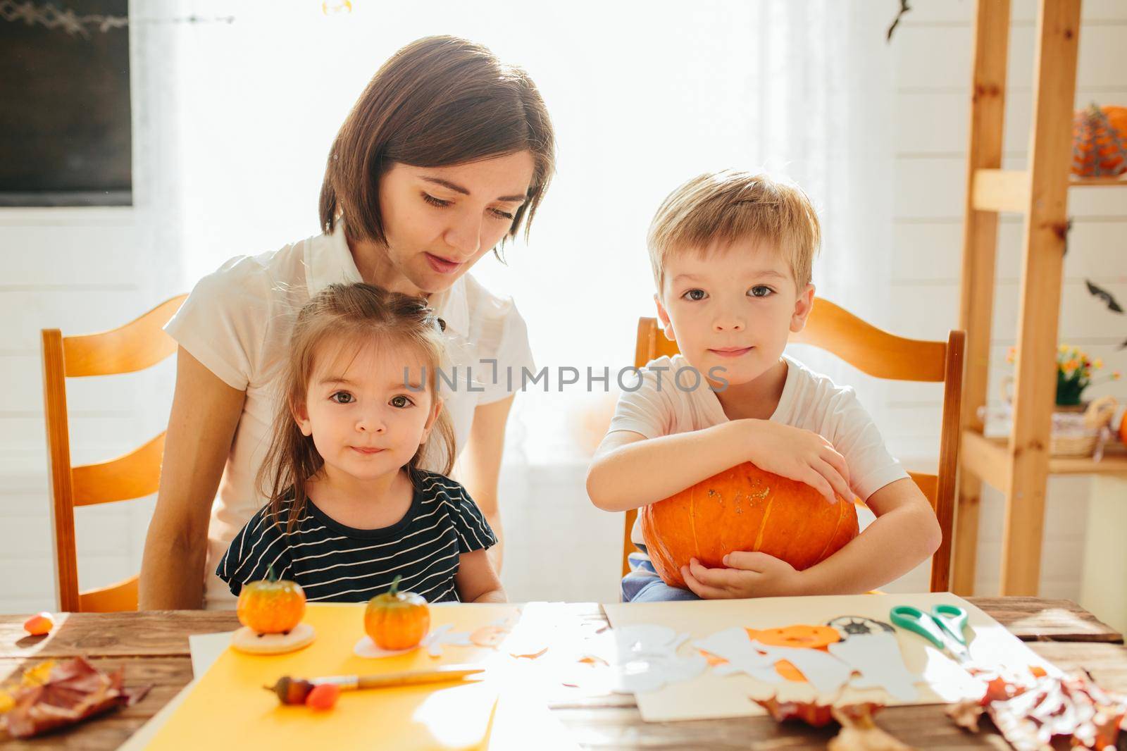 Mother and her kids having fun at home. Happy Family preparing for Halloween. Happy Halloween concept .