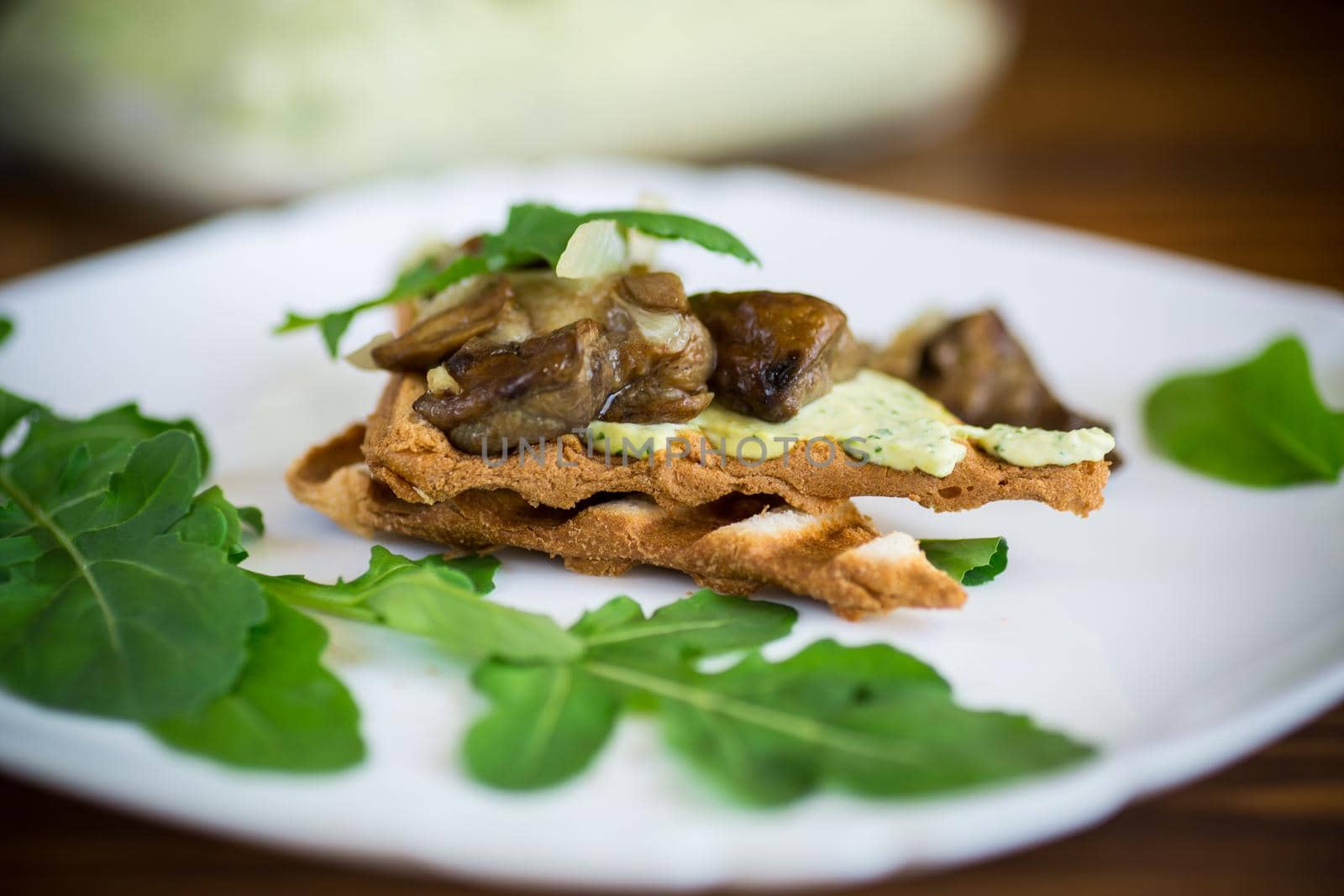 fried toast with cheese spread, arugula and fried mushrooms in a plate