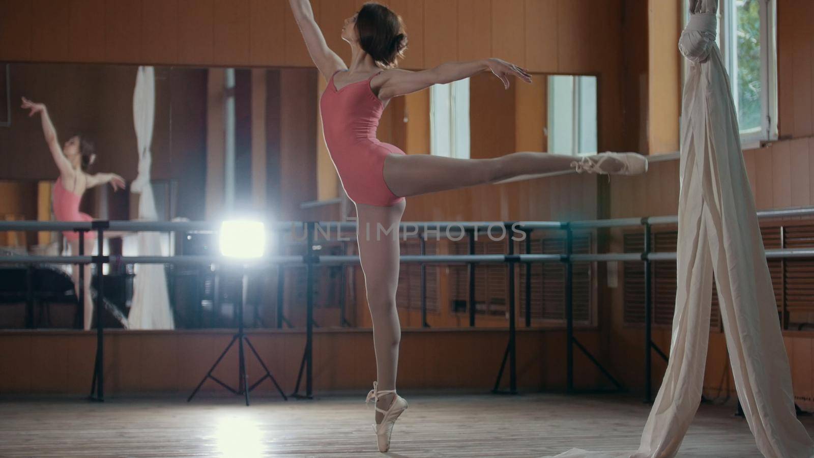 Young acrobatic girl shows the flexibility of the body at the ballet bar, circus artist