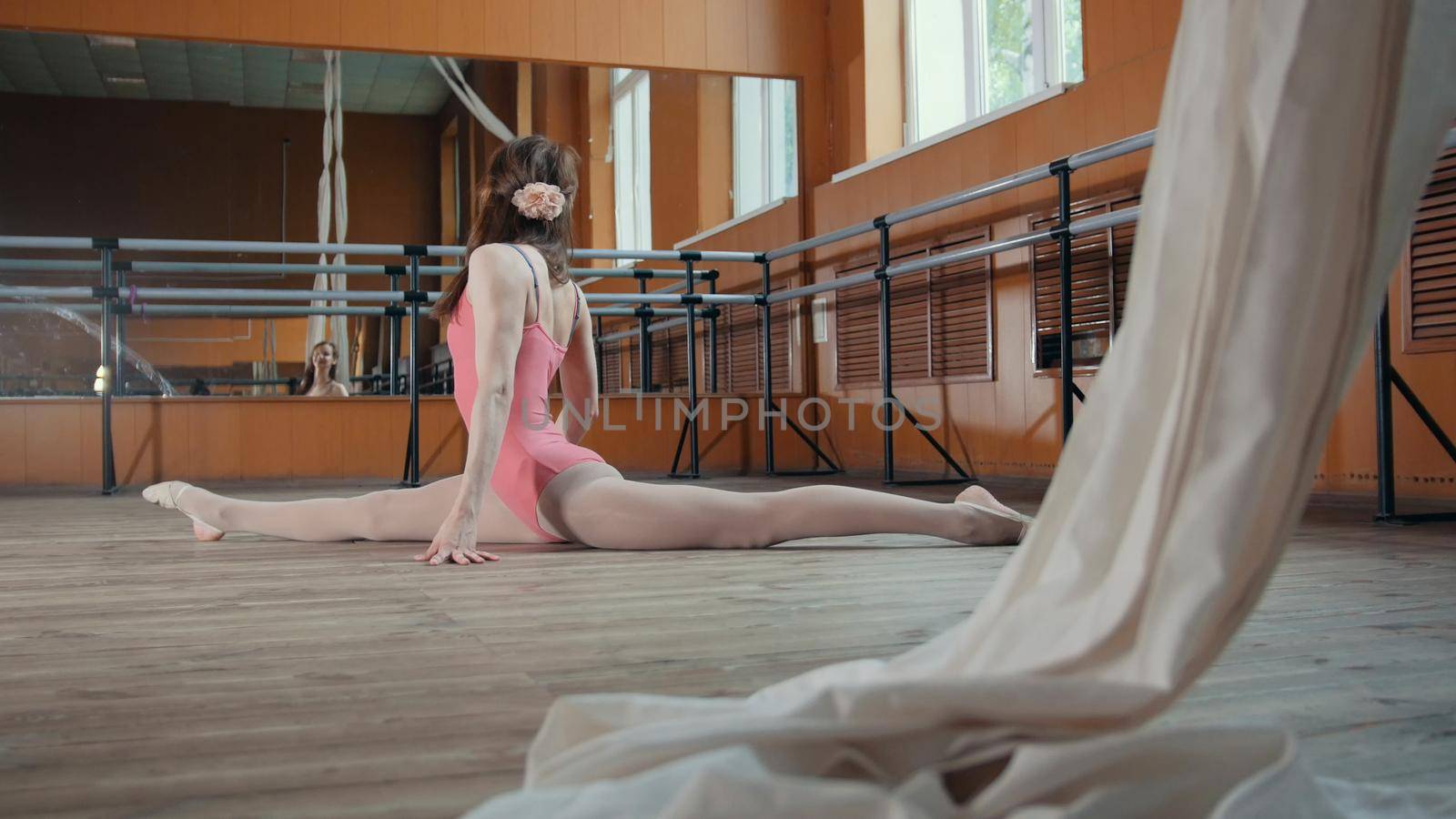Teen sport - model girl acrobatic sits on a splits, circus artist