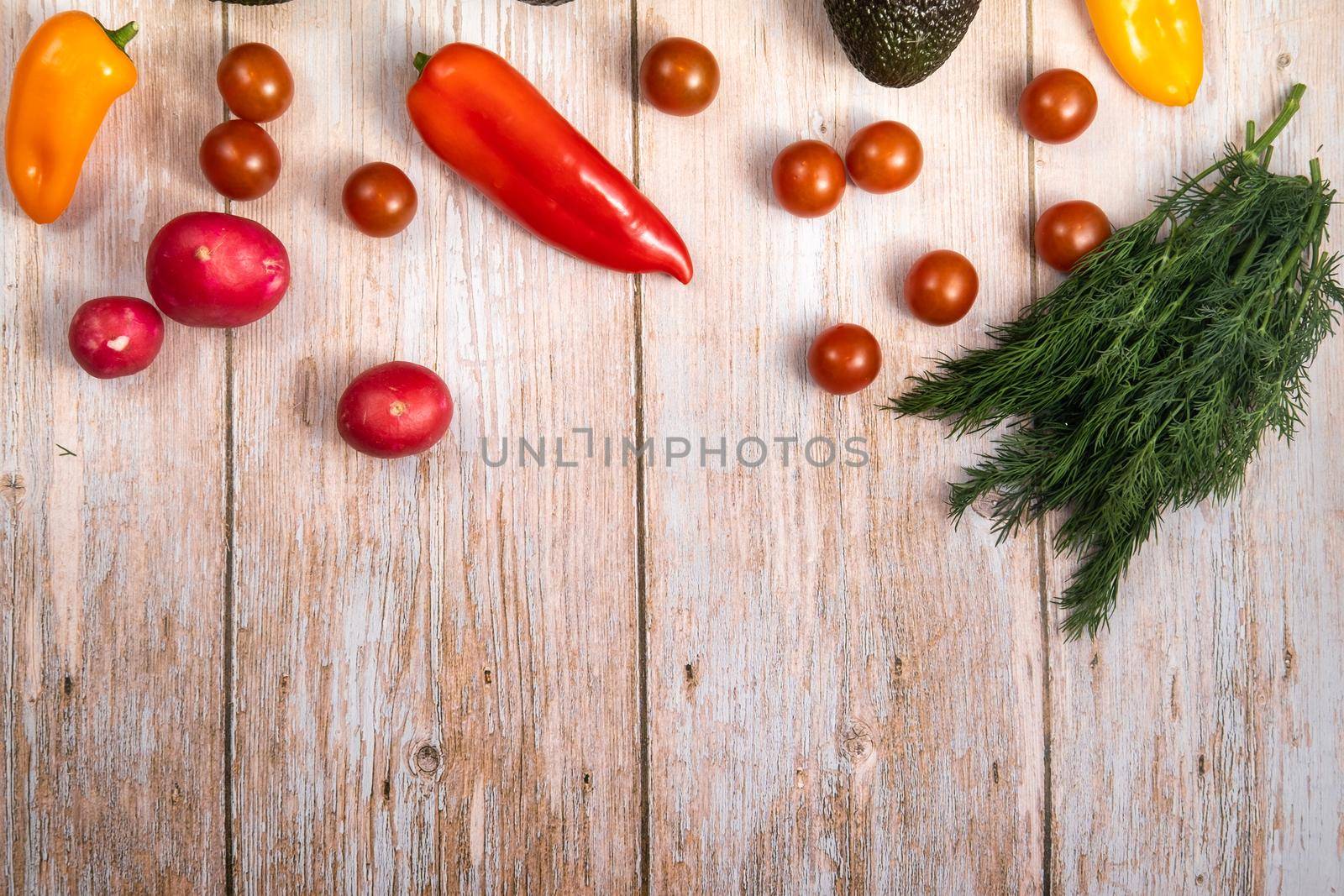 Assorted vegetables lying on a wooden table by Lobachad