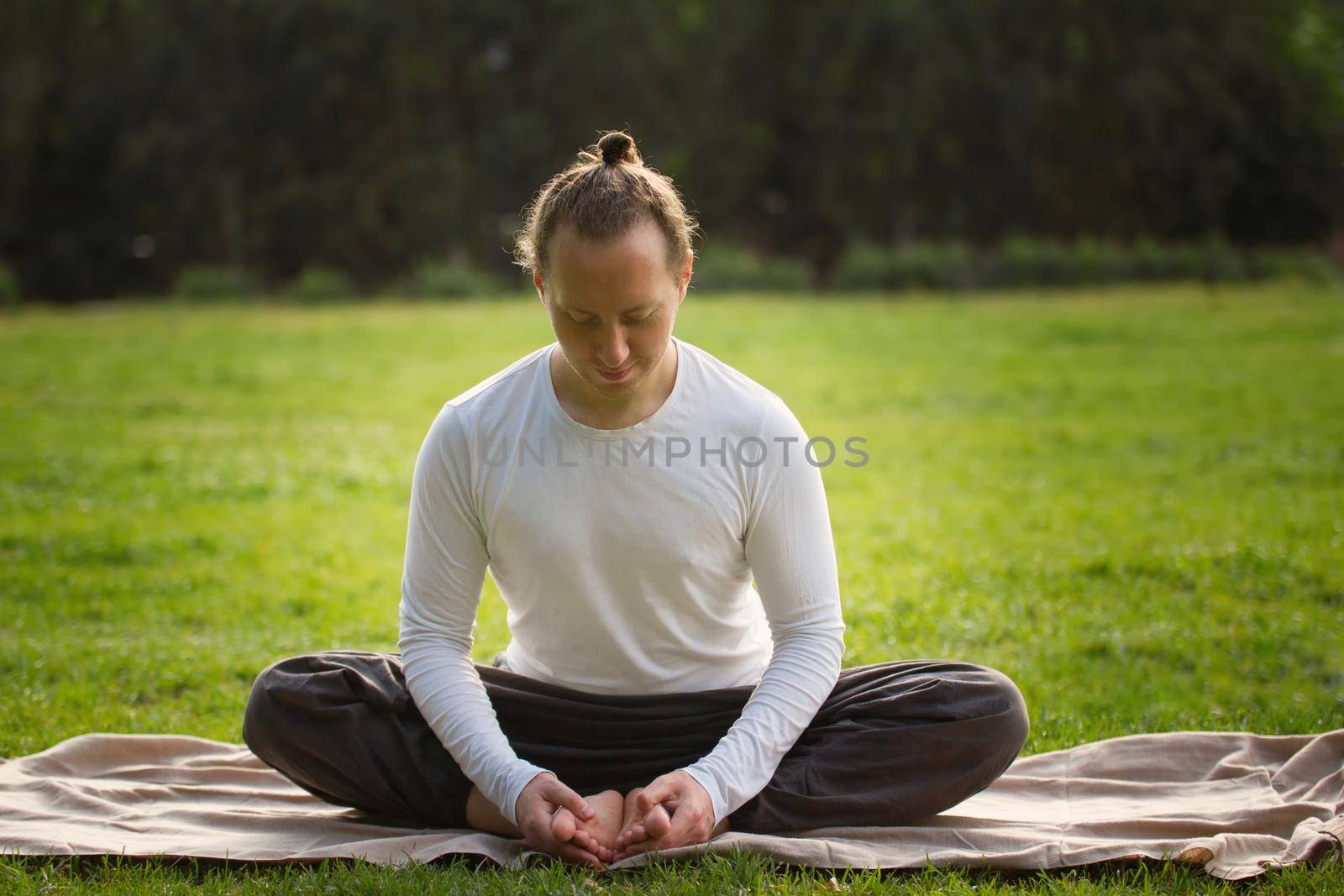 The yoga instructor in the lotus posture relaxes after exercising, outdoor