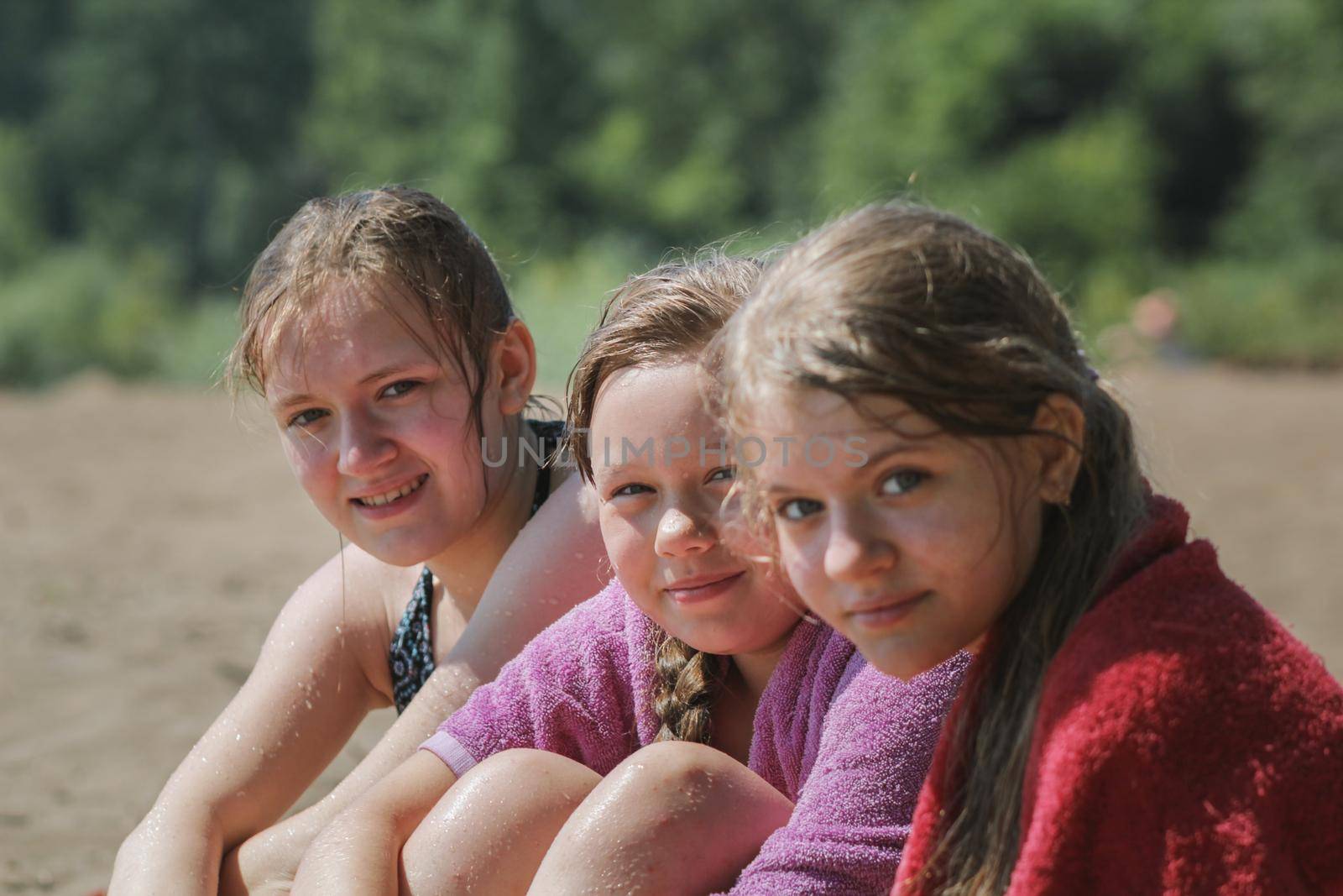 Happy three teen girlfriends on the beach after river swimming by Studia72