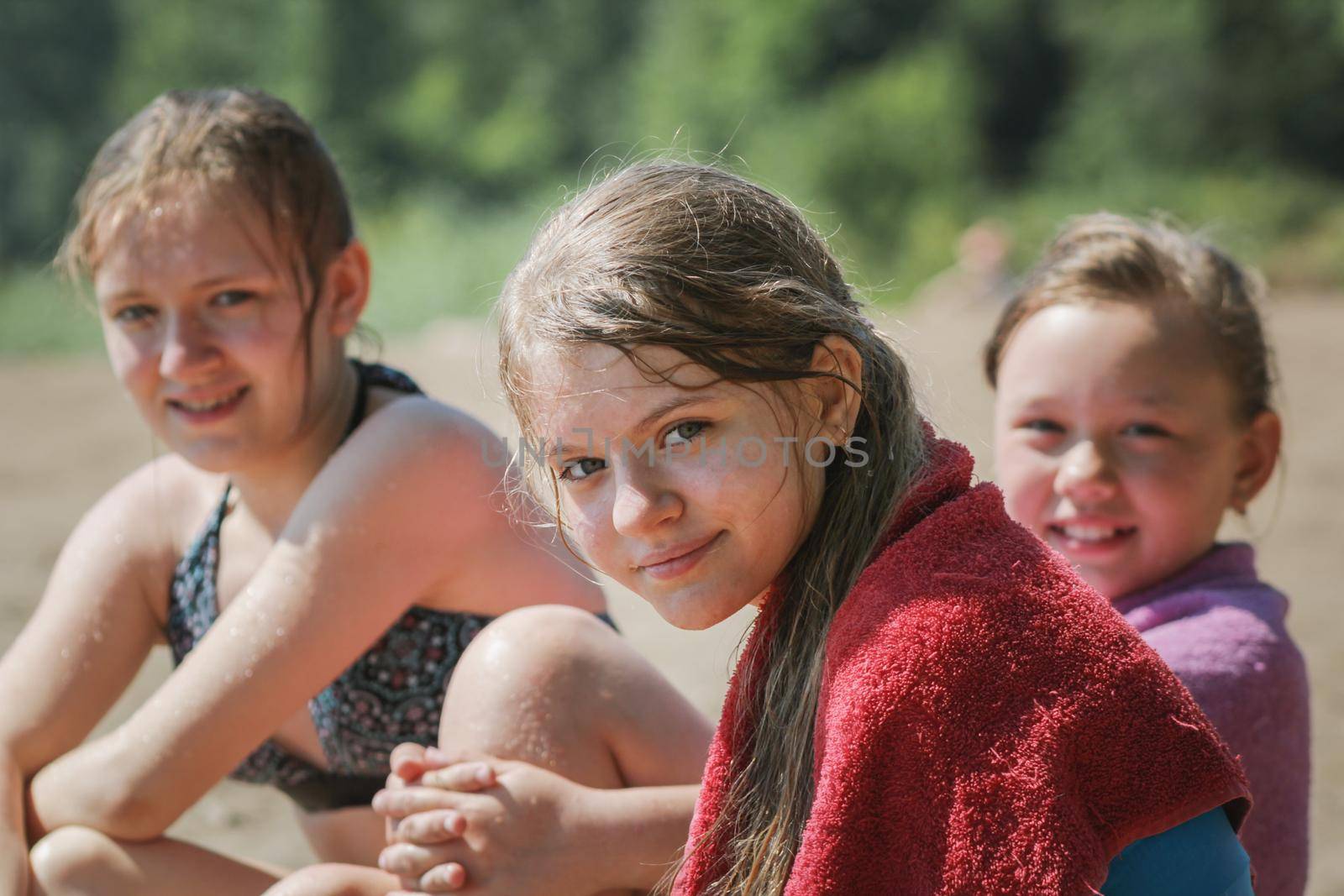 Happy three teen friends girls on beach after swimming, portrait