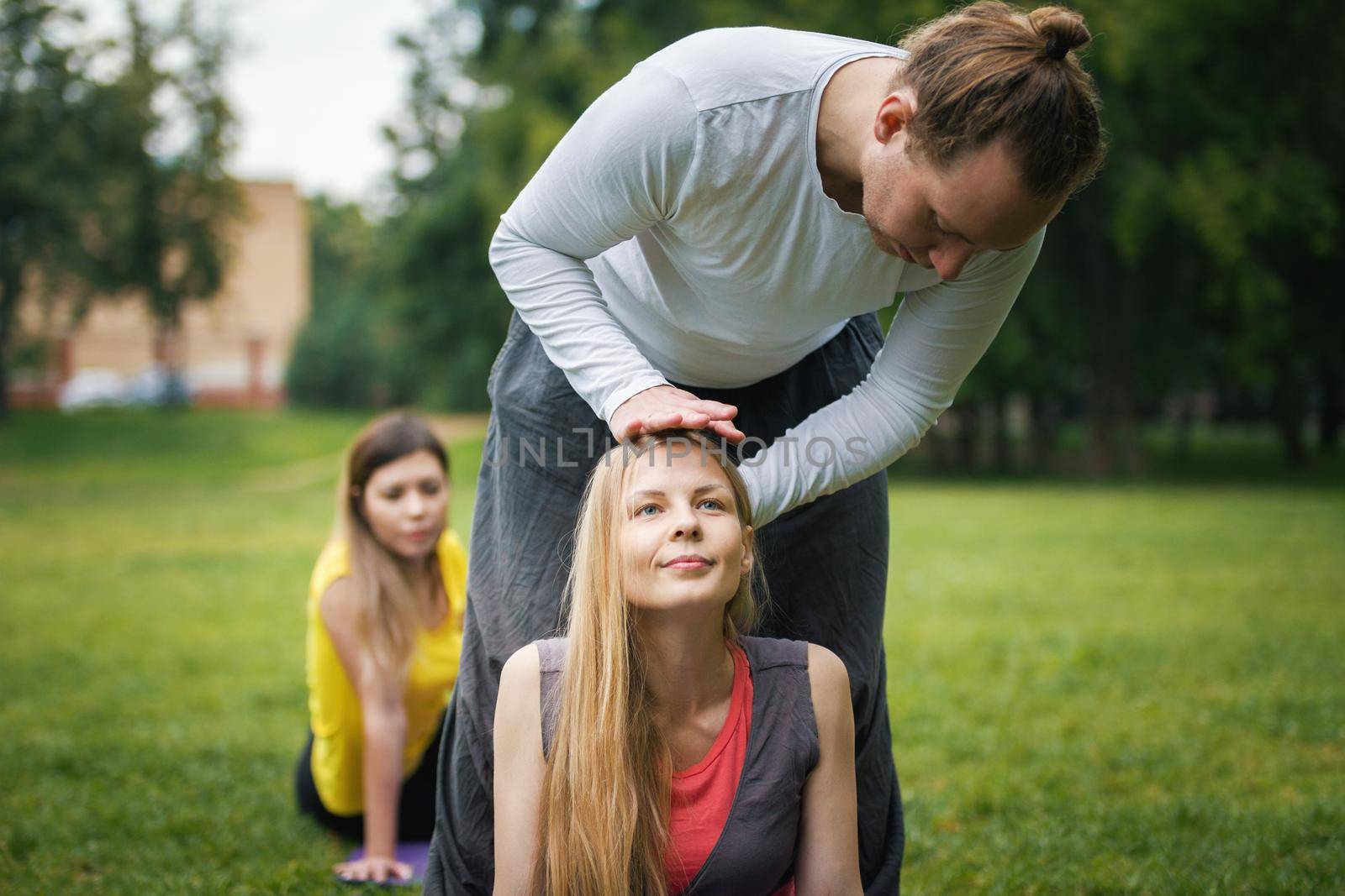 Yoga in morning park - instructor is training young women for flexibility by Studia72
