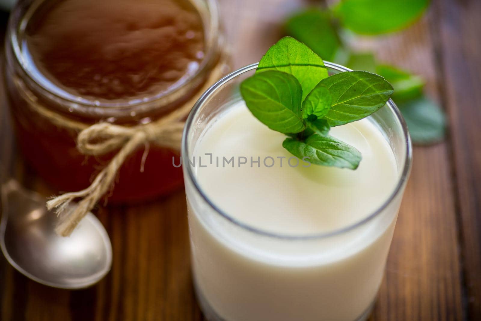homemade yogurt in a glass and with jam on a wooden table