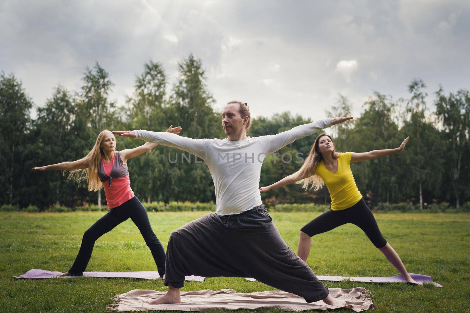 Yoga sportsmen in park - performs exercise outdoors outdoor at morning by Studia72