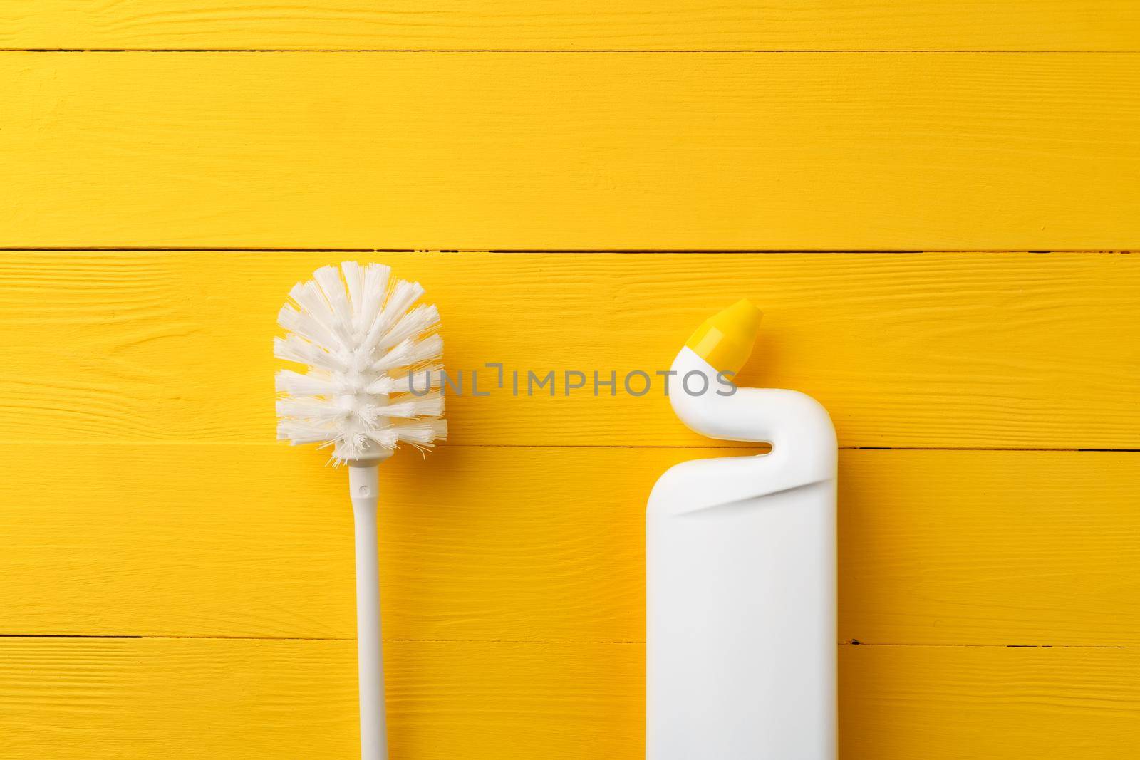 Household cleaning brush on yellow wooden background, top view