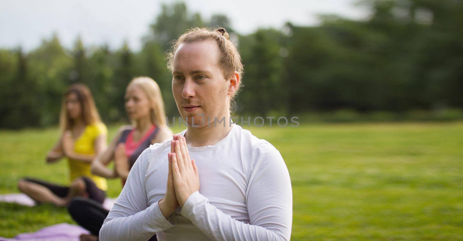 Yoga sportsmen in park - performs exercise outdoors outdoor at morning, telephoto shot