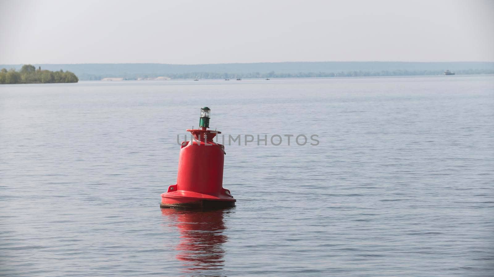 Red river buoy for ships on water - summer day, telephoto